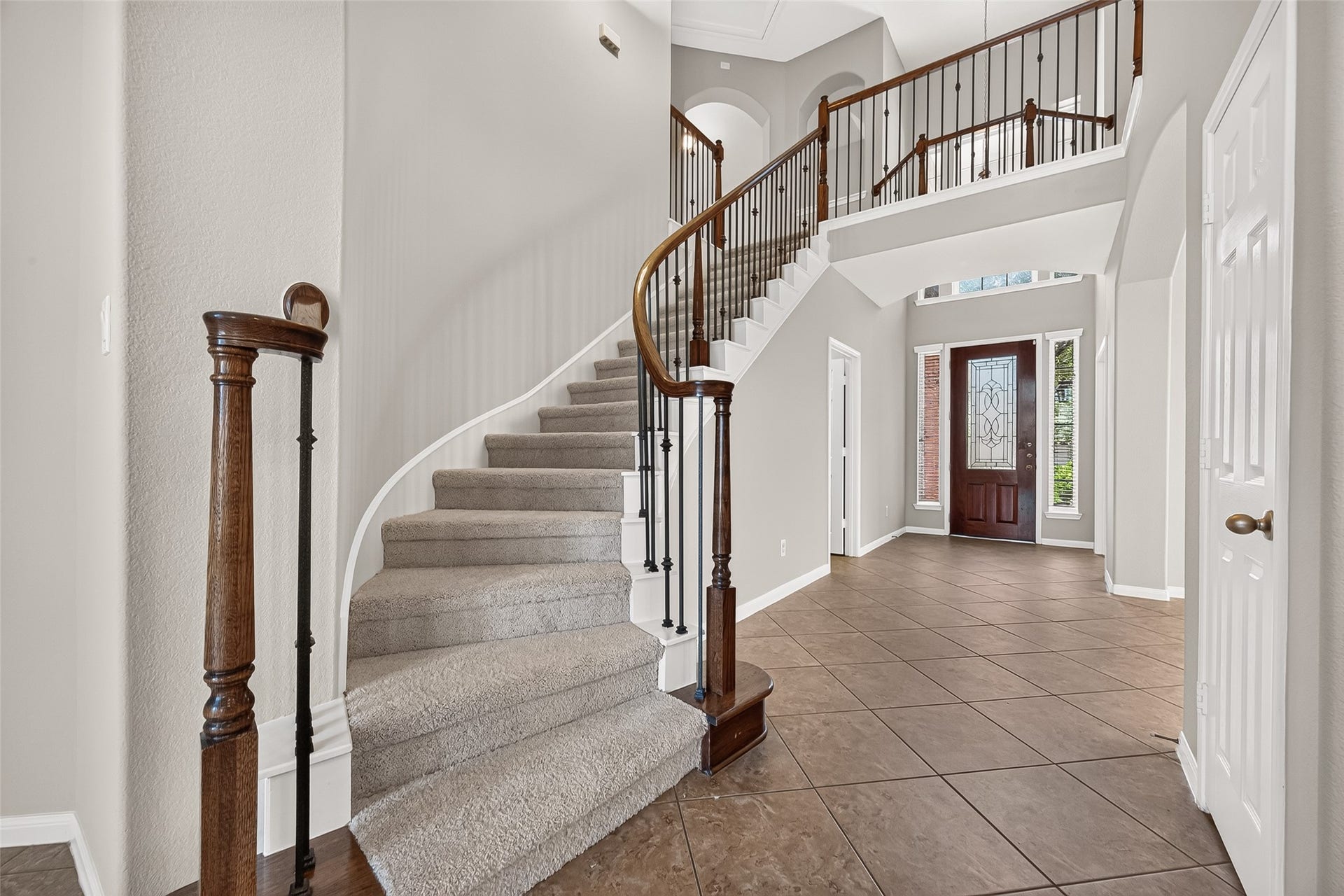 25710 Owl Landing Lane, Katy, TX 77494 Curved stairs with iron rod railings are the centerpoint of the home