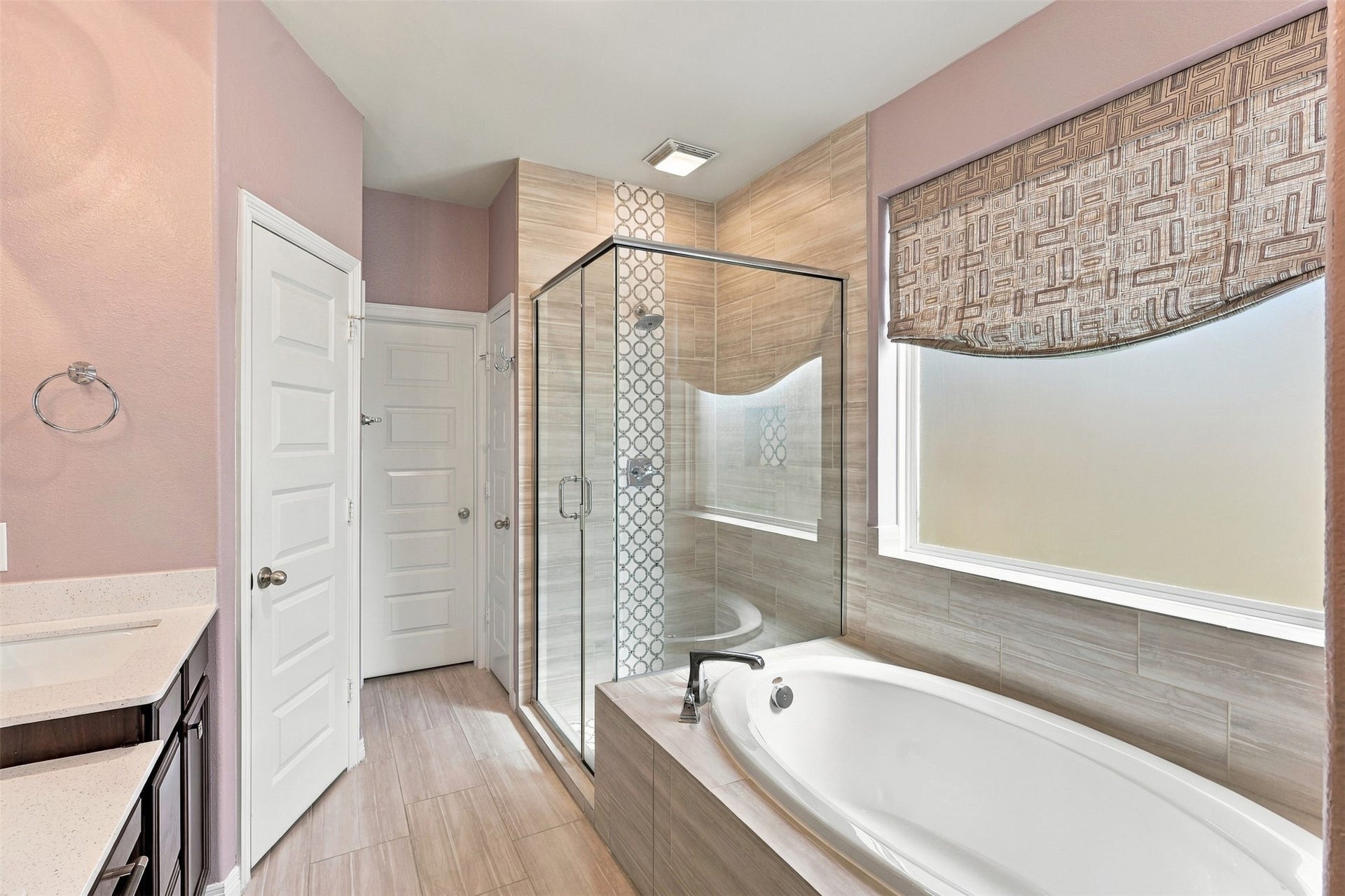 1719 Country Air Lane, Missouri City, TX 77459 Your own little retreat awaits! This inviting primary bathroom features a relaxing soaking tub, separate glass-enclosed shower, and a decorative window treatment that adds a touch of elegance. With its soft colors and thoughtful finishes, this space makes everyday routines feel a little more special.