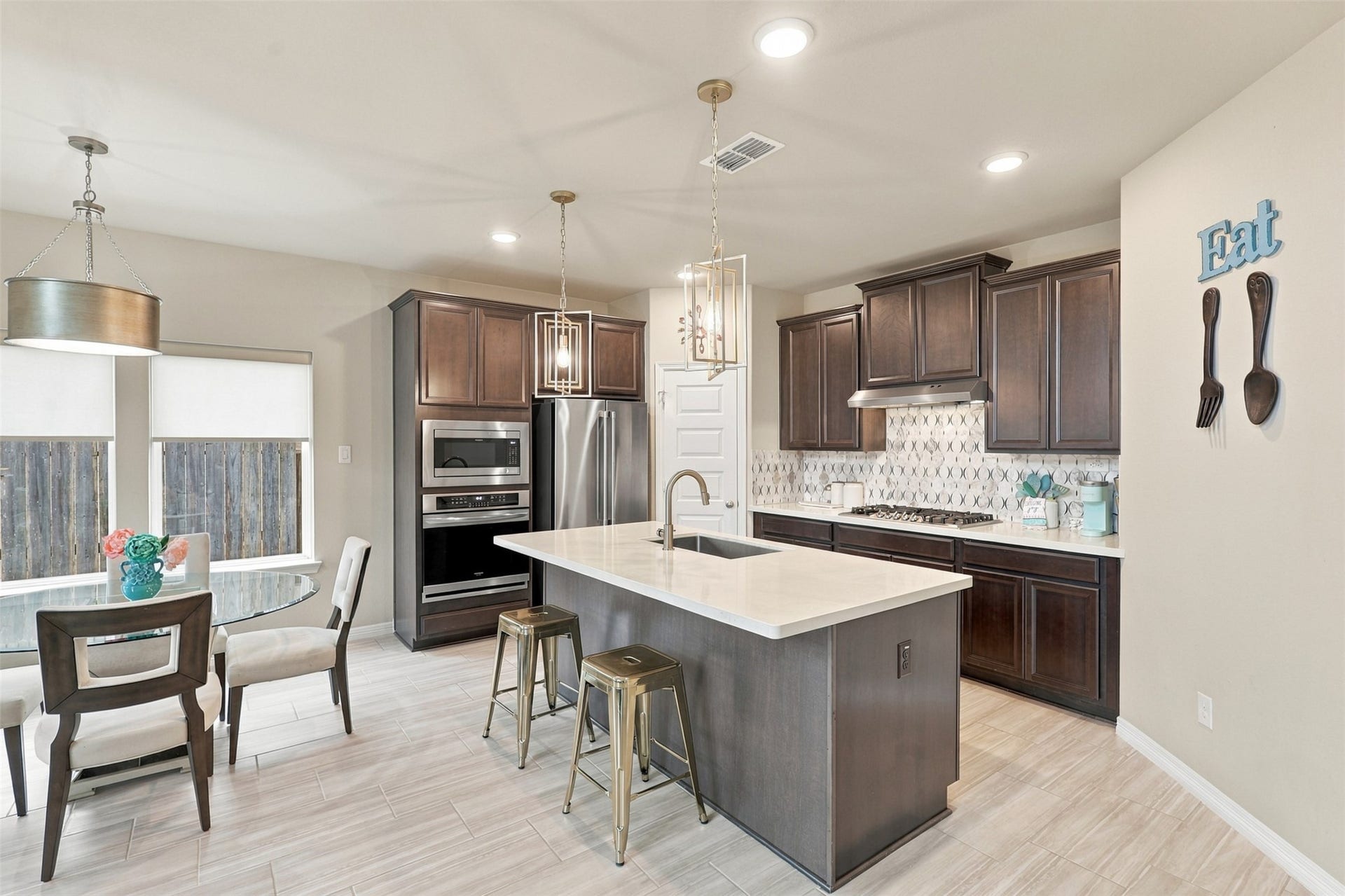 1719 Country Air Lane, Missouri City, TX 77459 WOW! A GOURMET KITCHEN THAT WILL STEAL YOUR HEART! Prepare to FALL IN LOVE with this stunning culinary masterpiece, where rich, elegant dark cabinetry beautifully contrasts with gorgeous quartz countertops and gleaming stainless-steel appliances! The magnificent, oversized island with inviting seating creates the PERFECT gathering spot for morning coffee, casual meals, and wonderful conversations!