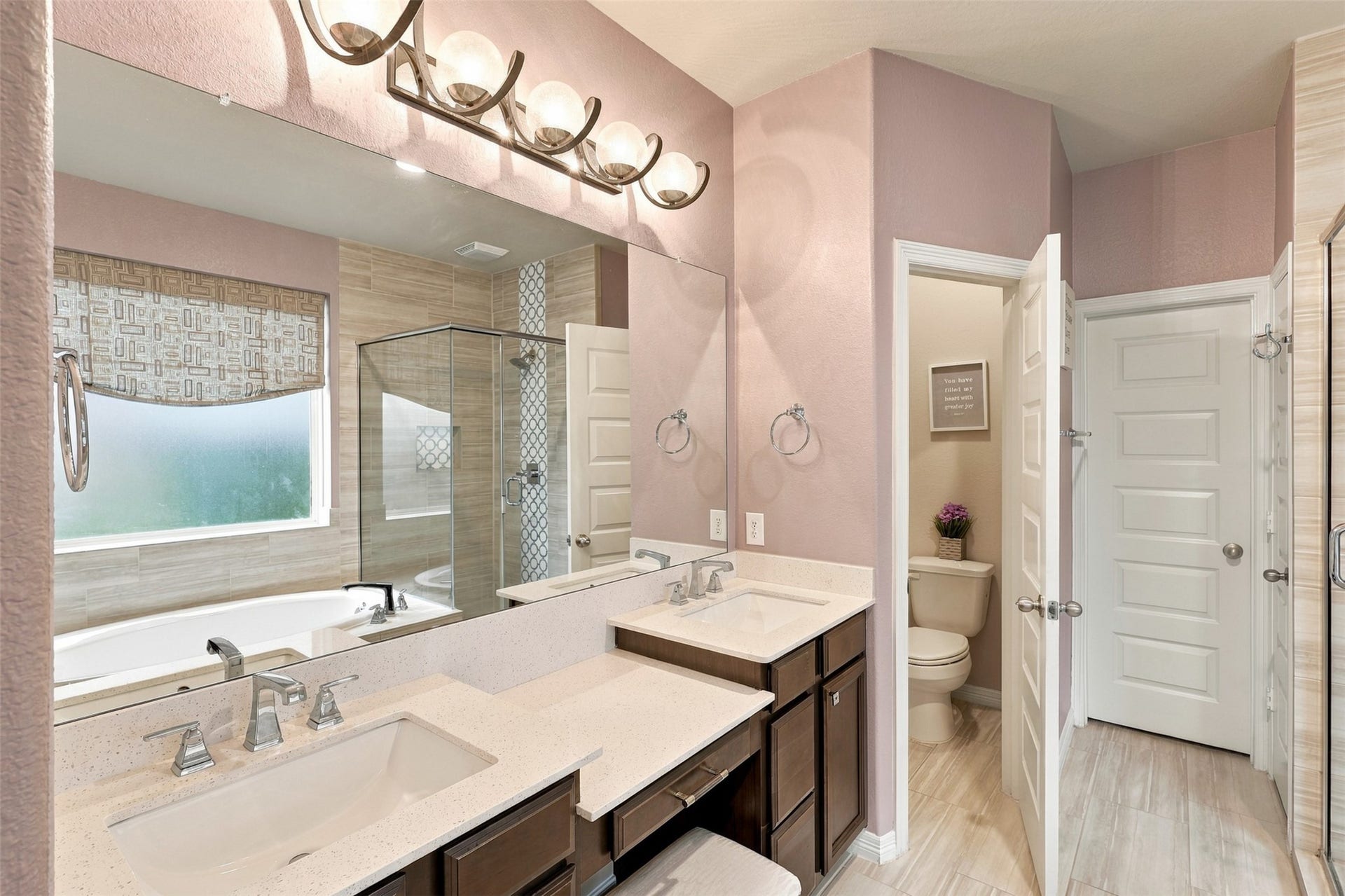 1719 Country Air Lane, Missouri City, TX 77459 YOUR VERY OWN SPA-INSPIRED SANCTUARY! Step into this BEAUTIFUL primary bathroom, where everyday luxury meets timeless elegance! The impressive vanity features dual undermount sinks, expansive countertops, and abundant drawers to keep all your essentials beautifully organized! Gorgeous designer lighting adds a touch of sophistication, while a large window welcomes wonderful natural light, creating a bright and refreshing atmosphere!