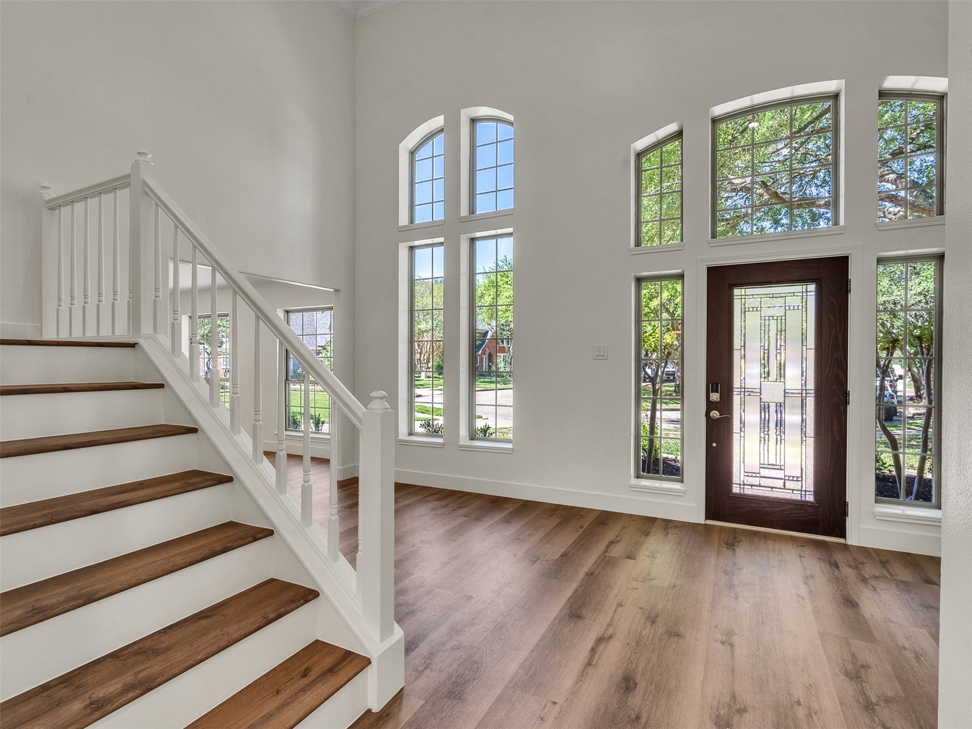 Bright, open entryway with high ceilings and large windows, enhancing natural light