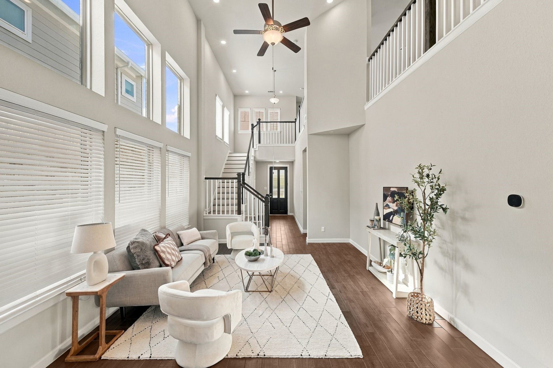 27022 Brighton Valley Way SW, Katy, TX 77494 Family room with wall mounted TV space, console table, and view back toward the stairs and entry.