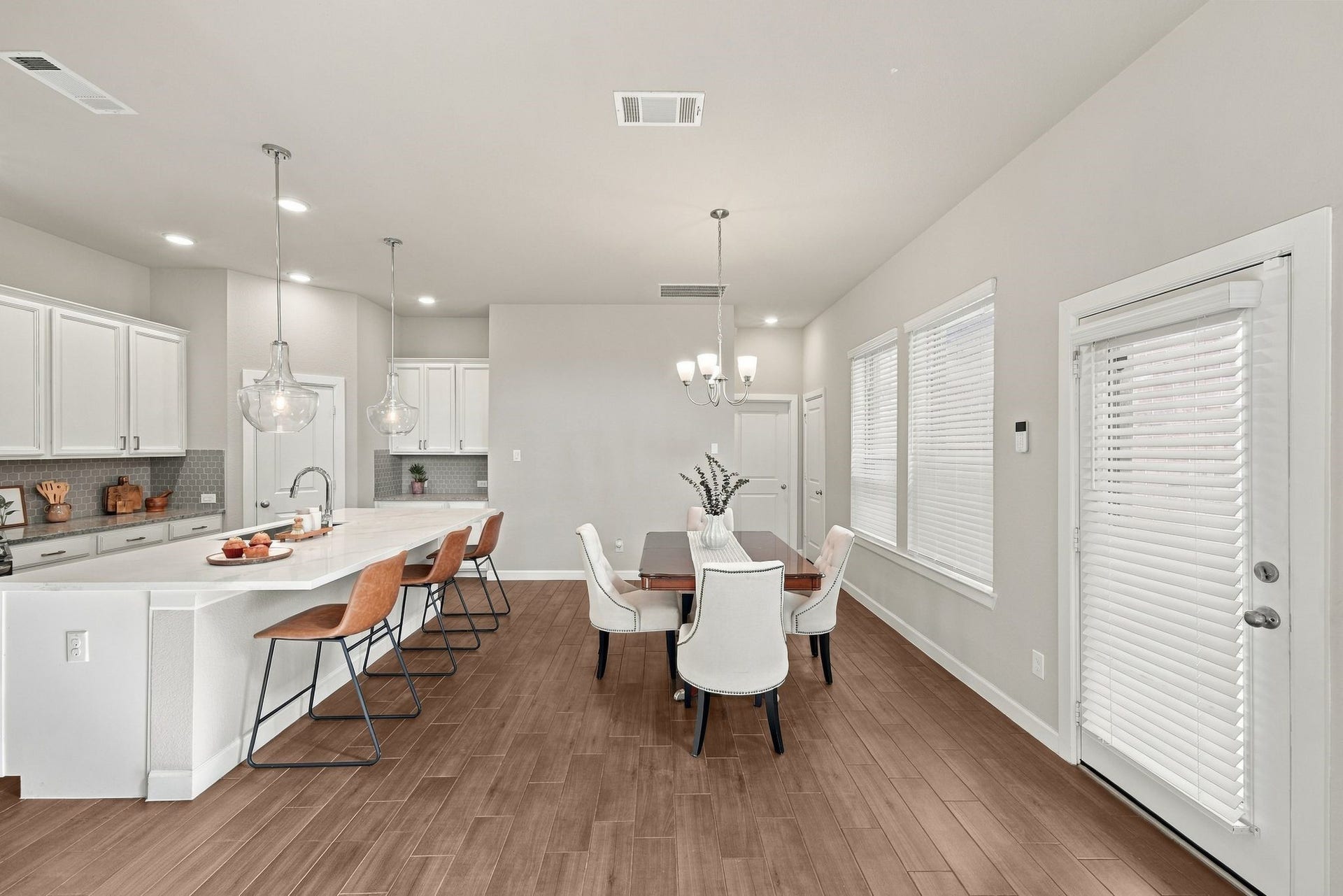 27022 Brighton Valley Way SW, Katy, TX 77494 Kitchen island with bar seating opens to the dining table and a door leading out to the backyard patio.