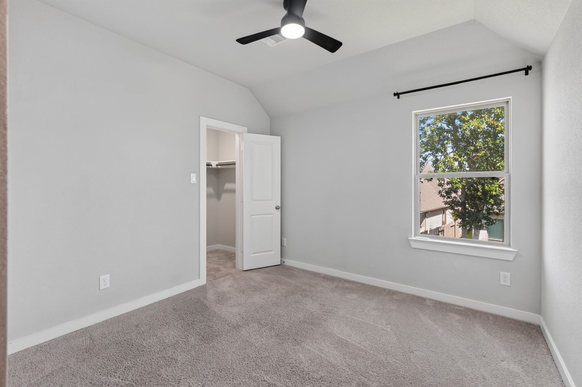 706 Santa Elena Trail, Conroe, TX 77304 Another secondary bedroom with a ceiling fan, plush carpet, and natural light from the window. Whether used as a kids' room, guest room, or home office, this bright and clean space offers the comfort and versatility needed for every stage of family life.