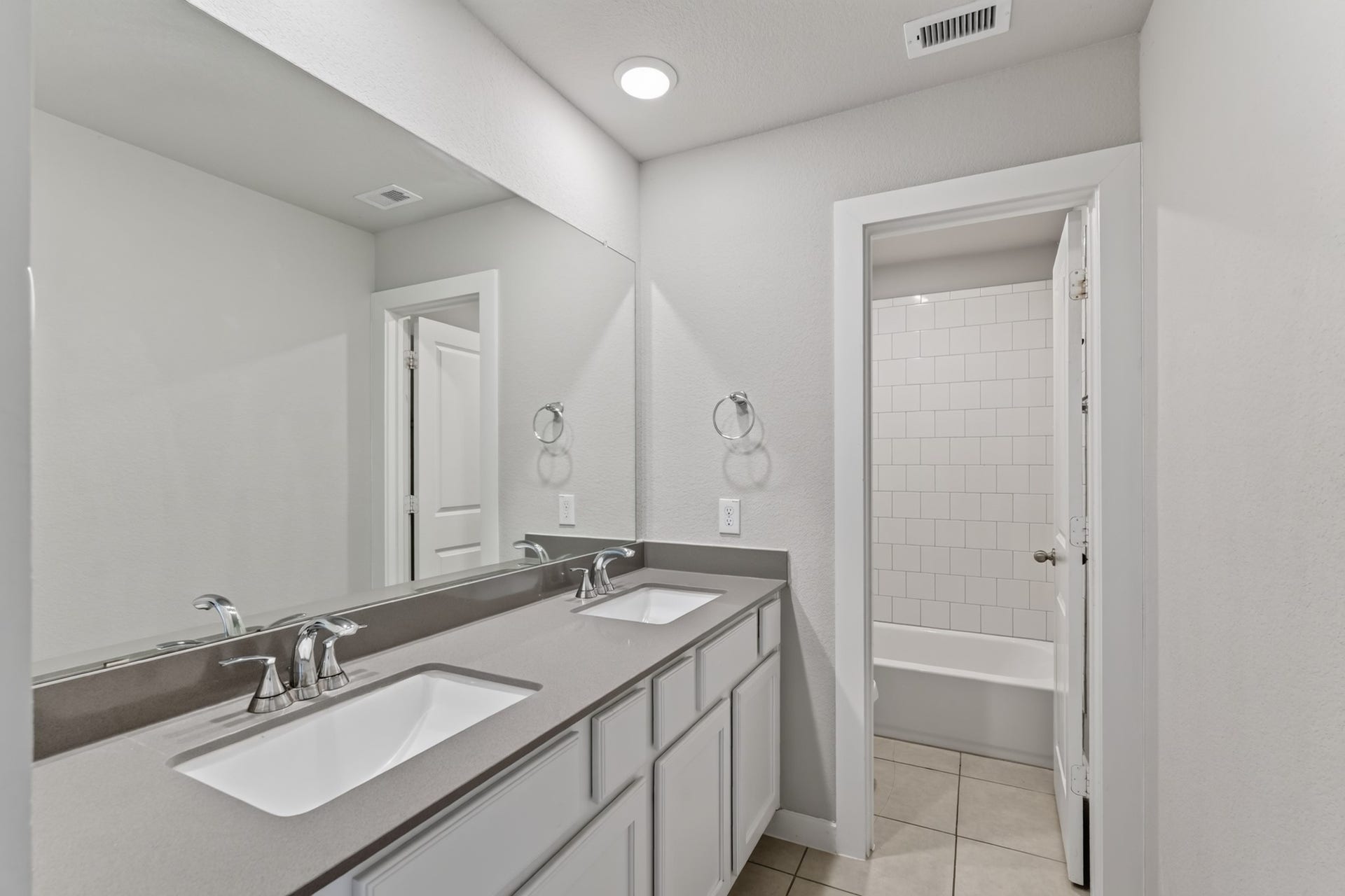706 Santa Elena Trail, Conroe, TX 77304 The upstairs shared bathroom features a double-sink vanity with a dark countertop and mirror ideal for busy morning routines when multiple family members need the space. Functional, stylish, and easy to maintain, it serves the secondary bedrooms beautifully.
