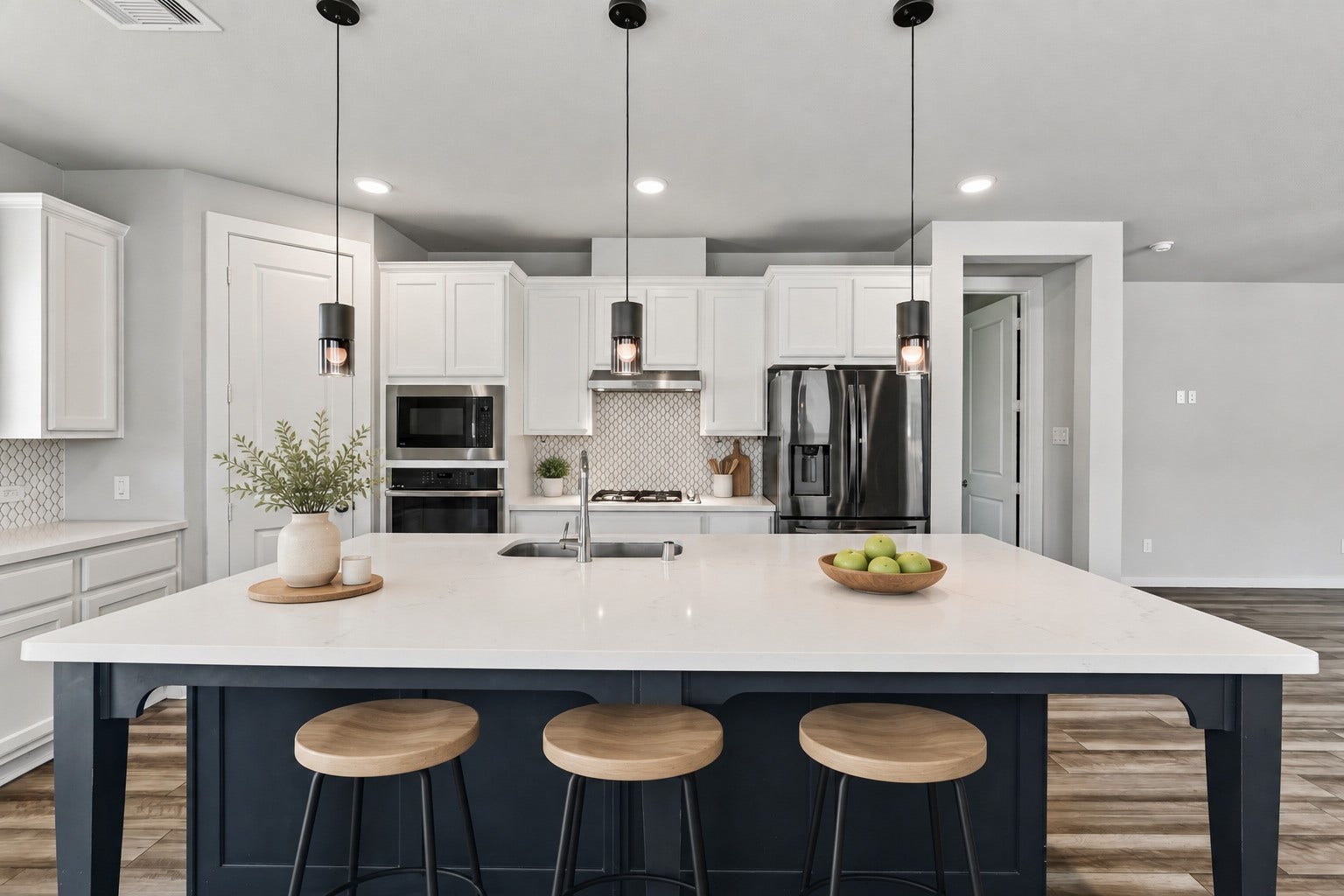 706 Santa Elena Trail, Conroe, TX 77304 The kitchen's oversized island is the centerpiece a brilliant white quartz countertop atop a striking navy blue base, surrounded by pendant lighting overhead. Ample seating and generous prep space make this stunning island the true heart of the home.