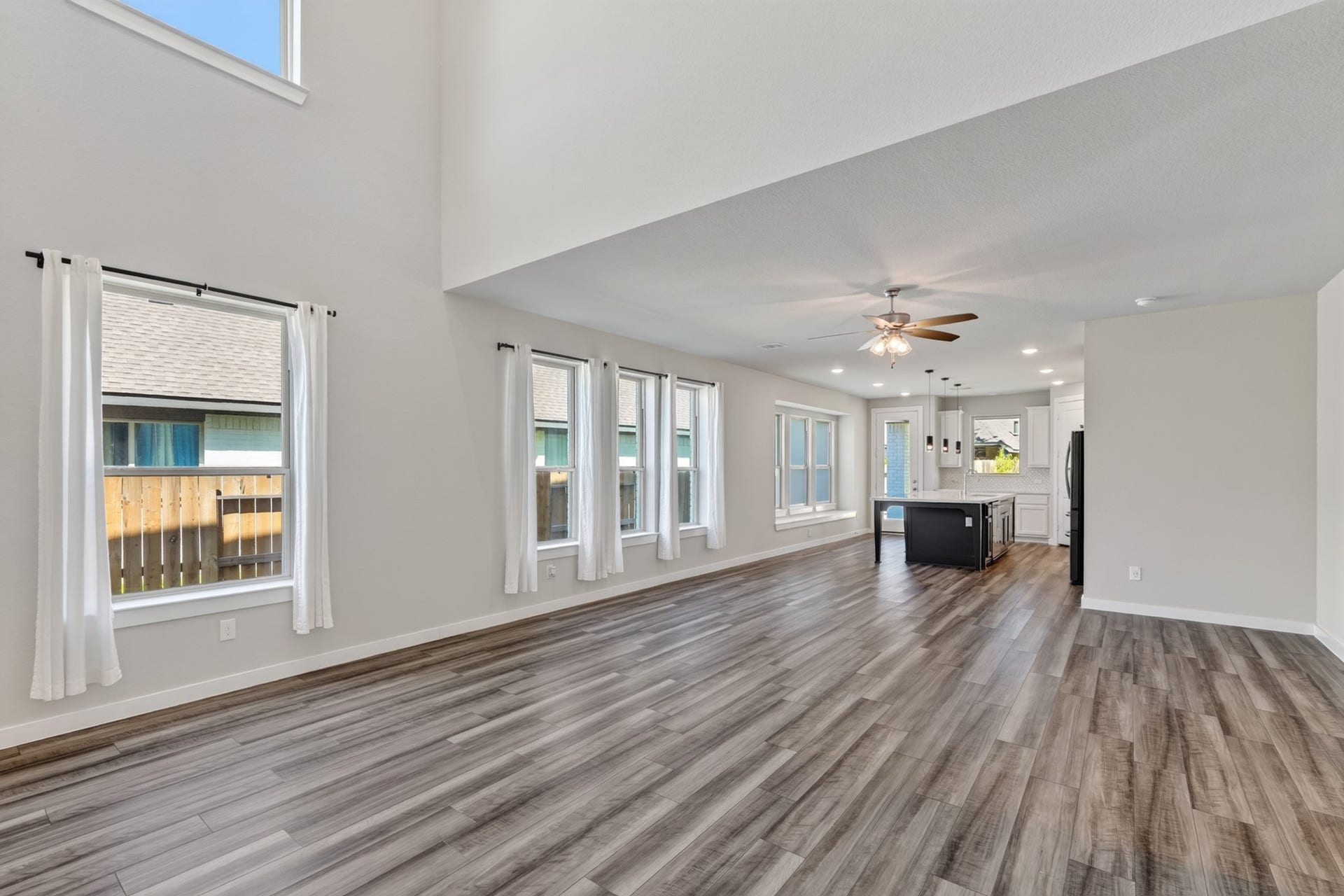 706 Santa Elena Trail, Conroe, TX 77304 The family room is flooded with natural light from oversized windows, with a ceiling fan overhead and gorgeous dark hardwood floors below. Open, bright, and generously sized this living space feels both expansive and naturally comfortable every single day.