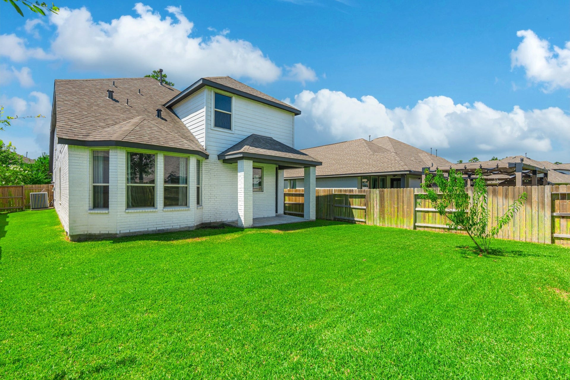 706 Santa Elena Trail, Conroe, TX 77304 Another rear exterior view highlights the generous green backyard and the home's clean, well-maintained exterior. Plenty of space to add a patio set, playset, or garden this yard is ready for whatever outdoor vision you bring to your new home.