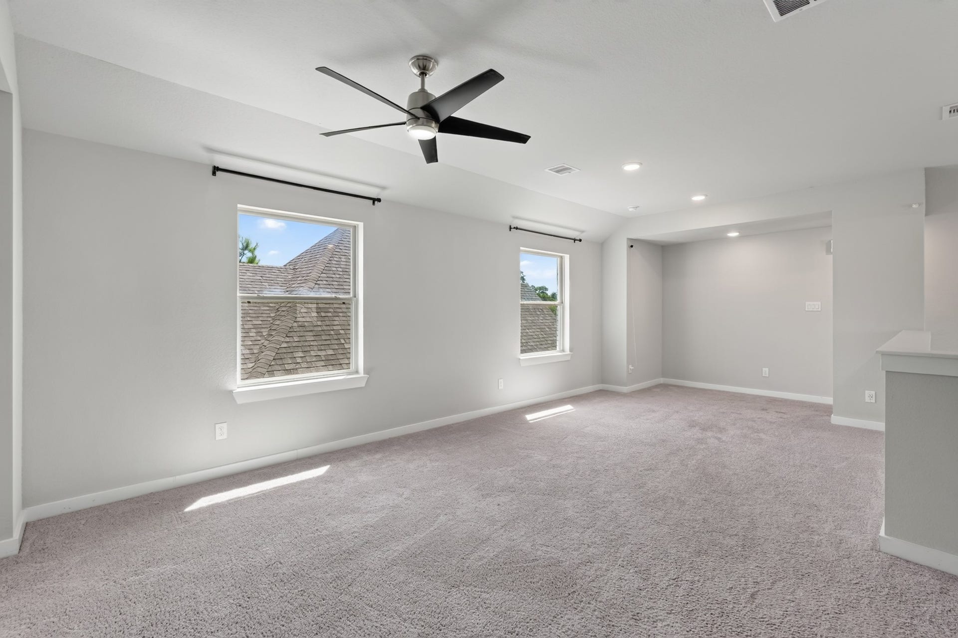 706 Santa Elena Trail, Conroe, TX 77304 Another view of the generous upstairs game room shows just how versatile and spacious this bonus area truly is. A ceiling fan, plush carpet, and neutral walls make this room a natural gathering spot for activities, entertainment, and everyday fun upstairs.