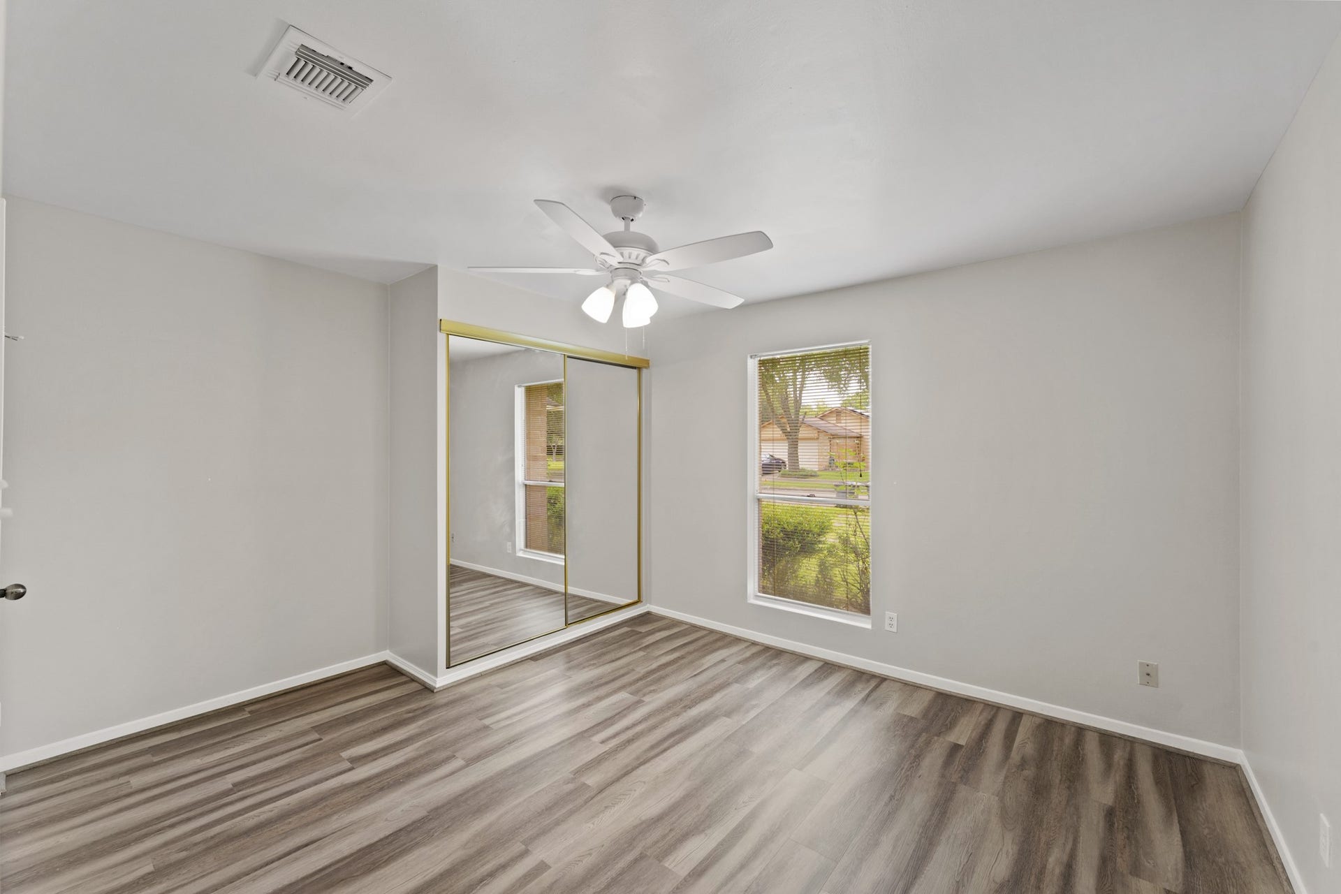 3926 Mill Rock Circle, Sugar Land, TX 77479 Secondary bedroom located on the first floor features beautiful wood-look floors, a ceiling fan, and a large window with privacy blinds!