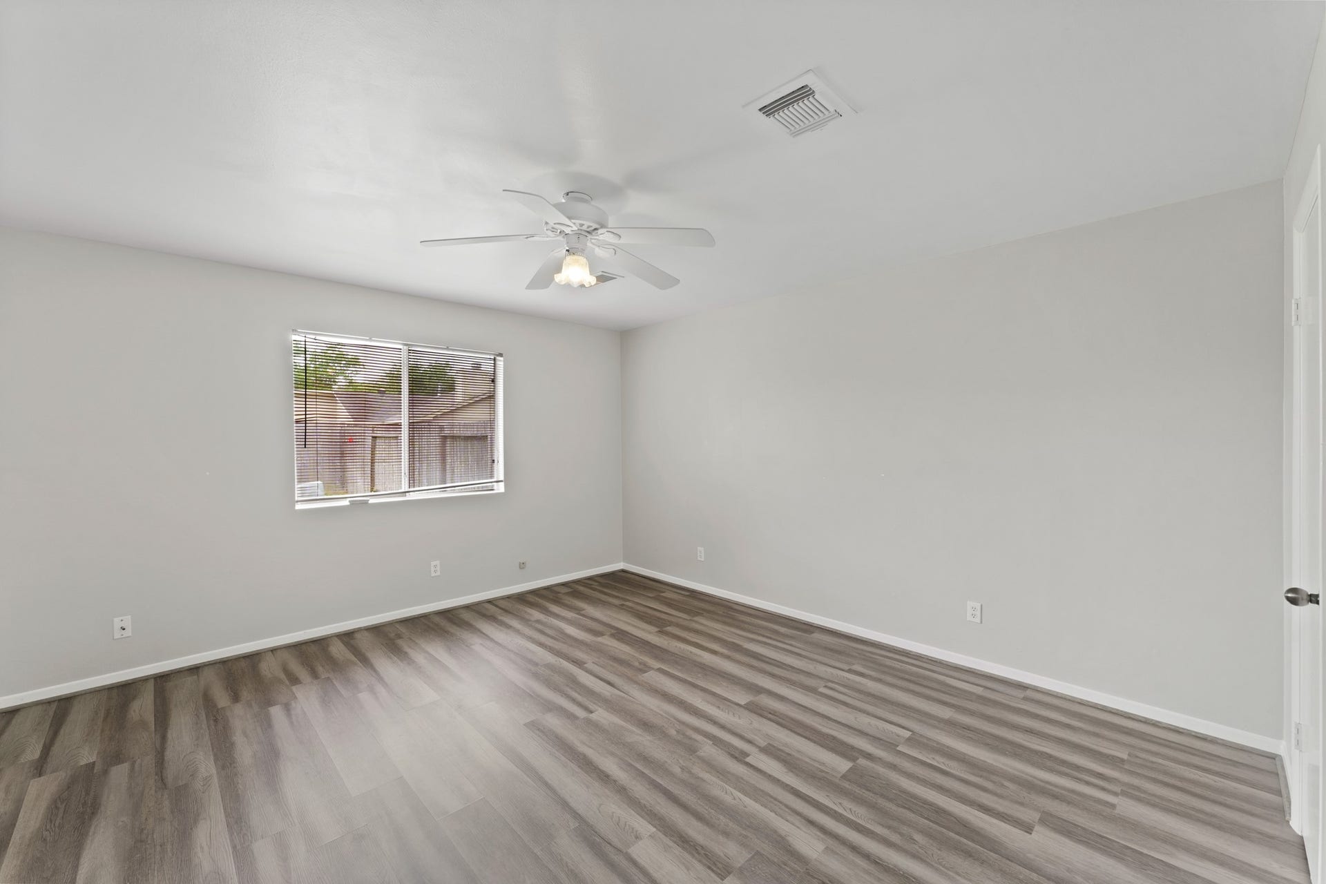 3926 Mill Rock Circle, Sugar Land, TX 77479 Secondary bedroom located on the first floor features beautiful wood-look floors, a ceiling fan, and a large window with privacy blinds!