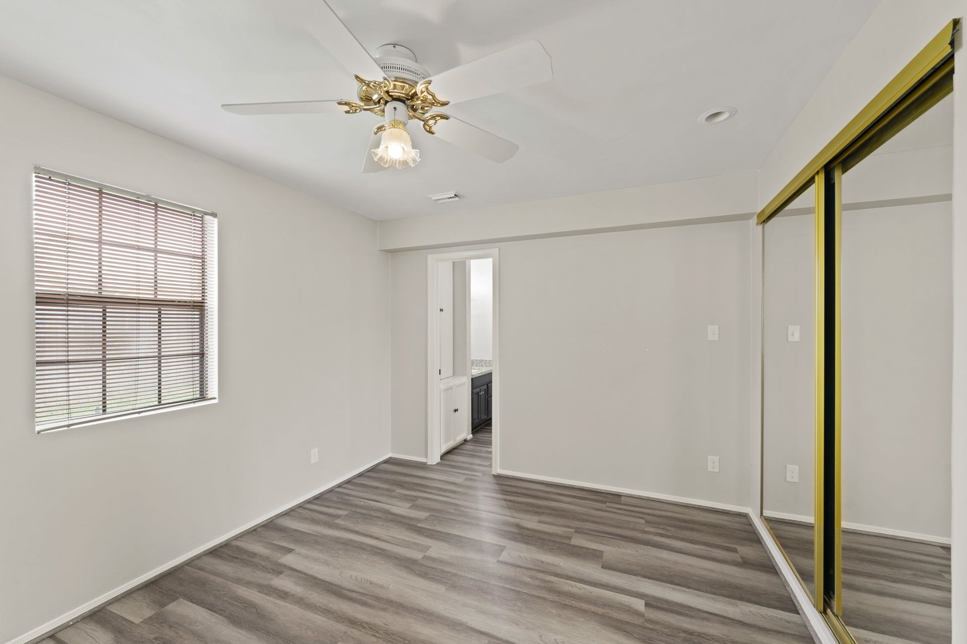 3926 Mill Rock Circle, Sugar Land, TX 77479 The spacious primary bedroom features wood look floors, a ceiling fan, and a large window with privacy blinds!
