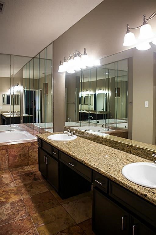 Double sink inside master bathroom with granite countertops