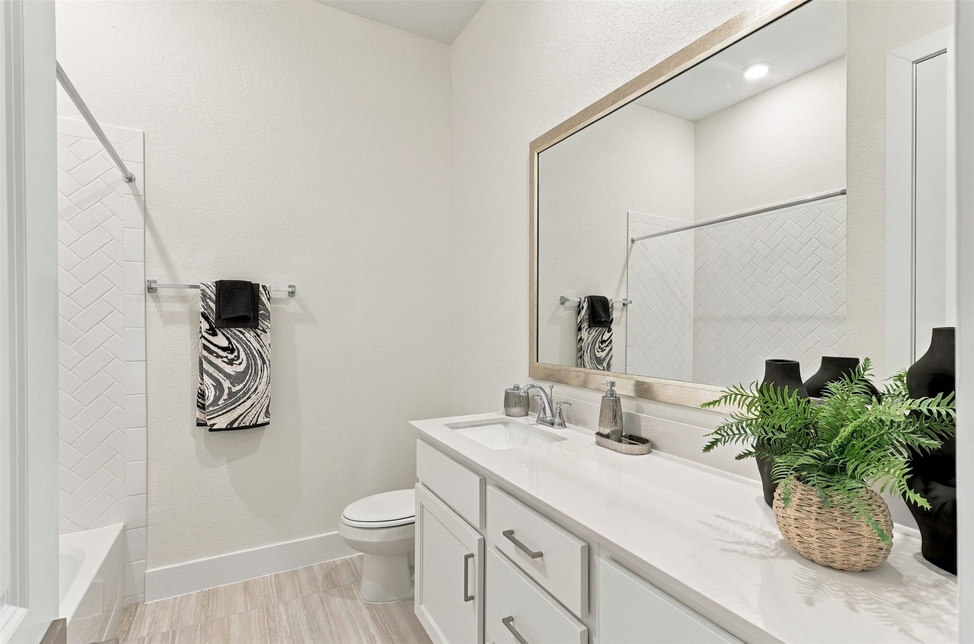 1051 Lakeland Circle, Rosharon, TX 77583 EVERYDAY LUXURY WITH A TOUCH OF ELEGANCE! This BEAUTIFUL SECONDARY BATHROOM is designed to IMPRESS! Enjoy a SPACIOUS VANITY showcasing GORGEOUS QUARTZ COUNTERTOPS, a DEEP UNDERMOUNT SINK & an abundance of CABINET AND DRAWER STORAGE to keep everything beautifully organized! Notice the STUNNING LARGE-FORMAT TILE FLOORING that adds a sophisticated, custom touch! And the finishing detail? An ELEGANT DESIGNER-FRAMED MIRROR for that touch of class!