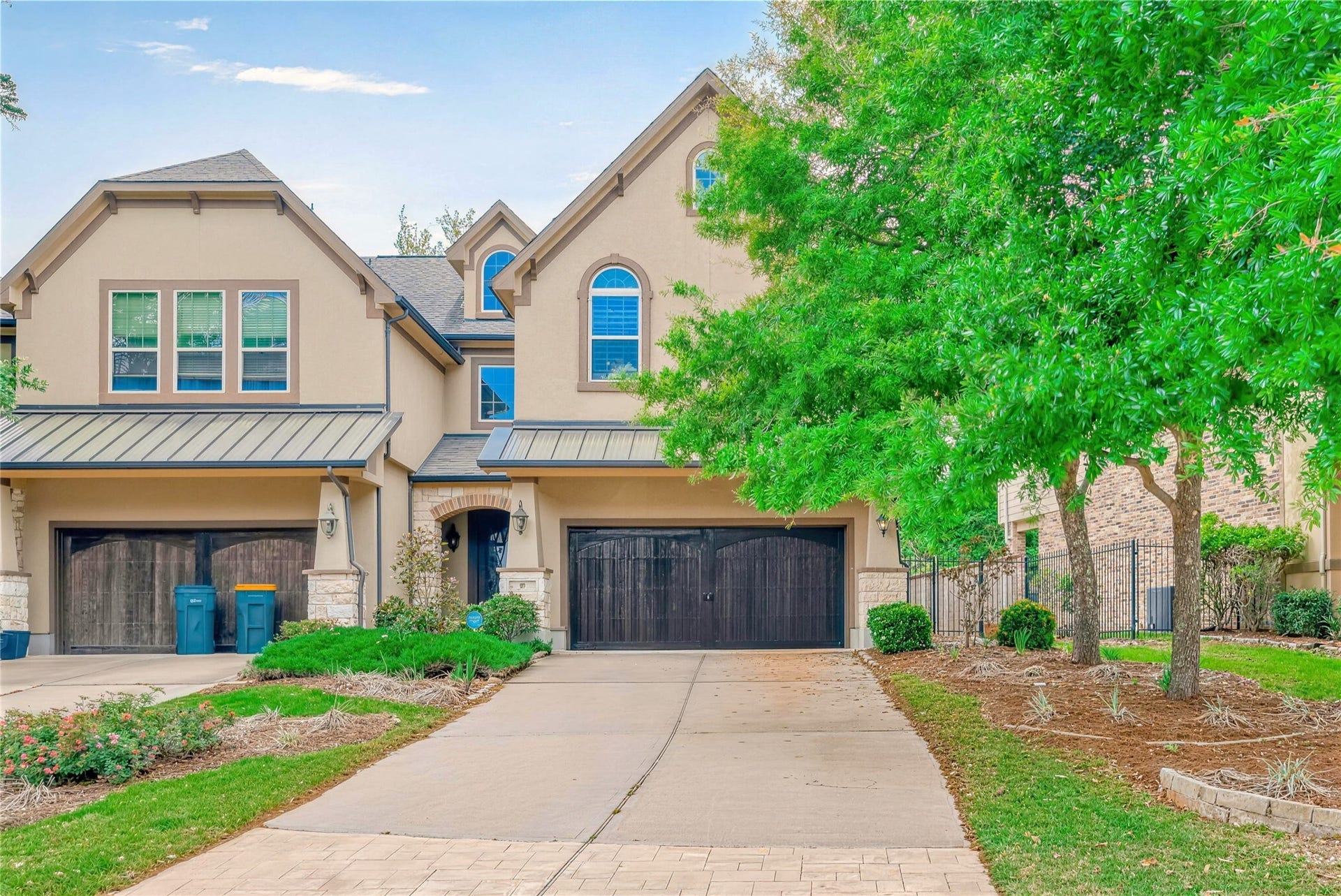 19 Herons Flight Place, Spring, TX 77389 Charming two-story home with elegant arched windows and a spacious driveway leading to an attached garage, accented by lush greenery and a well-maintained front yard.
