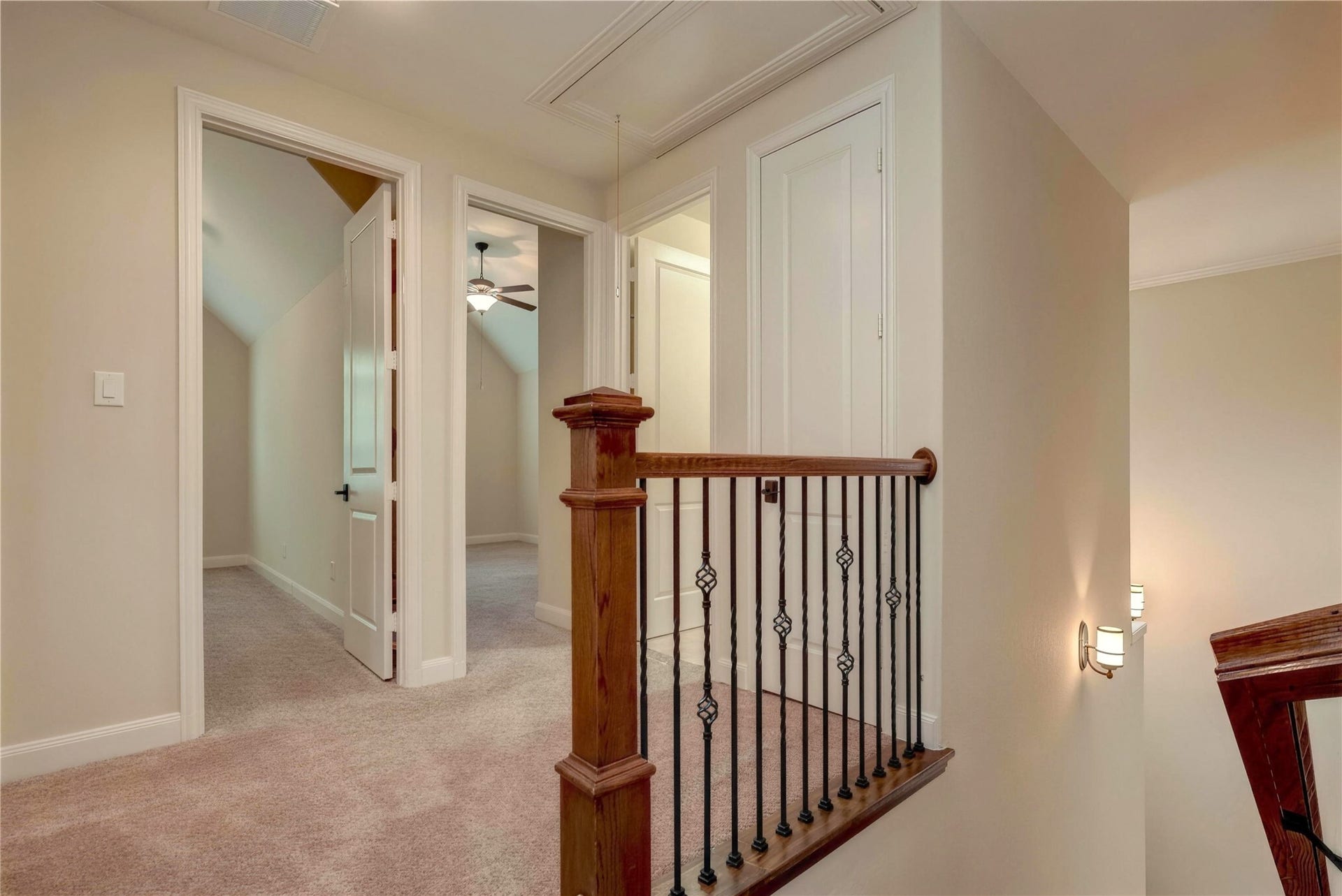 19 Herons Flight Place, Spring, TX 77389 Charming upstairs landing with plush carpeting, featuring elegant wood and iron railings, and access to multiple rooms with a cozy ambiance.