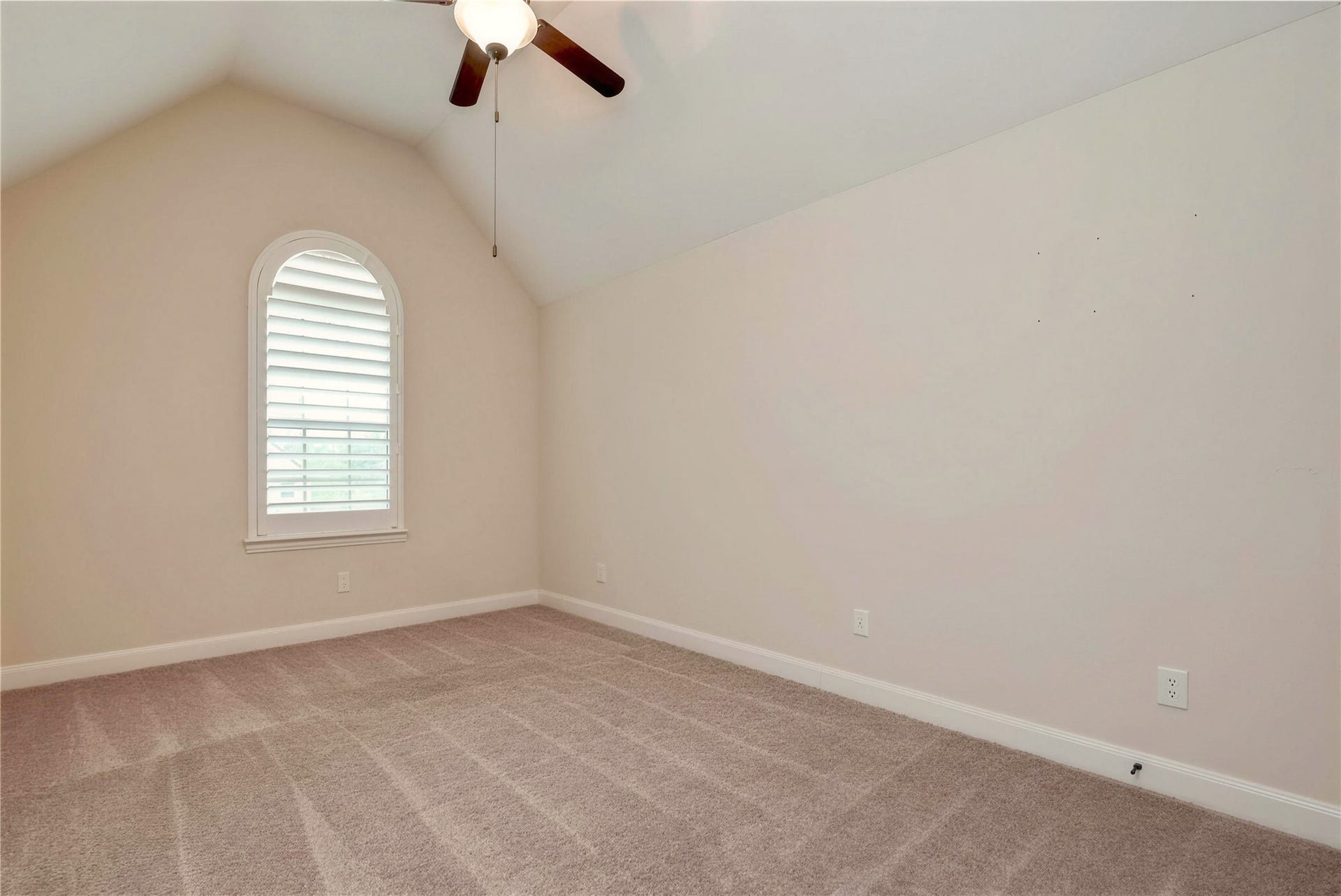 19 Herons Flight Place, Spring, TX 77389 Bright, airy room with vaulted ceiling, plush carpeting, and a charming arched window featuring plantation shutters.