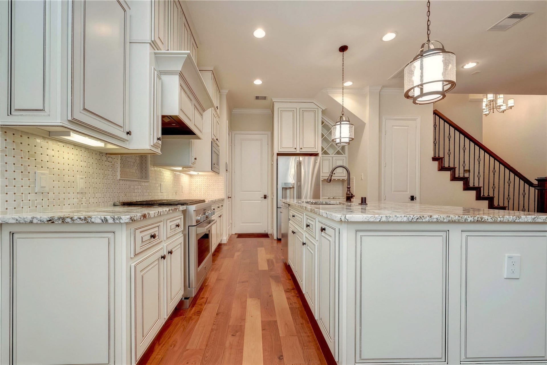 19 Herons Flight Place, Spring, TX 77389 Elegant kitchen featuring custom cabinetry, granite countertops, and a spacious island with pendant lighting.