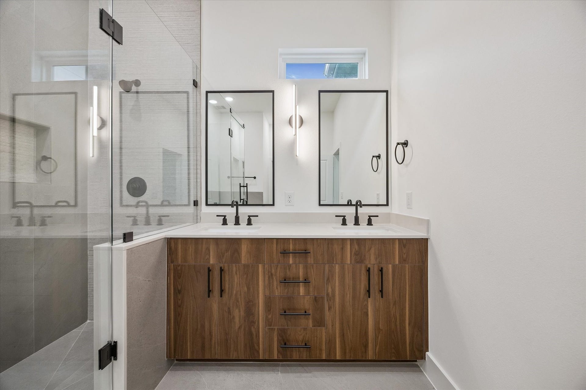 Dual-sink vanity with wood cabinetry and upgraded lighting