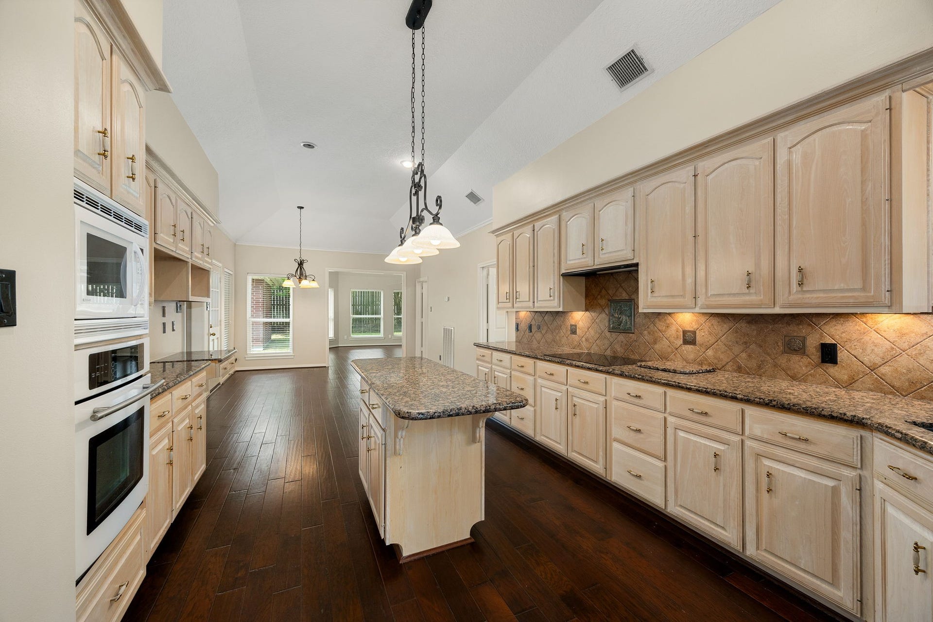 1602 Hannington Drive, Katy, TX 77450 The oversized kitchen offers an abundance of cabinetry and counter space, with a center island and plenty of room to work.