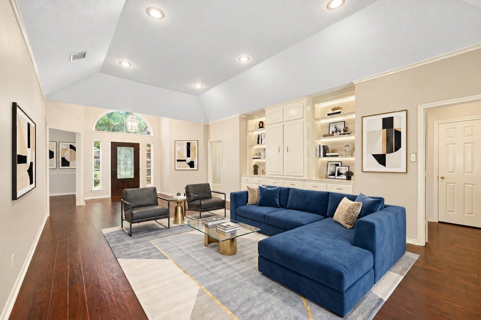 1602 Hannington Drive, Katy, TX 77450 The formal living room opens with high ceilings, hardwood floors and custom built-in cabinetry, creating a bright introduction to the main home. Virtually staged.