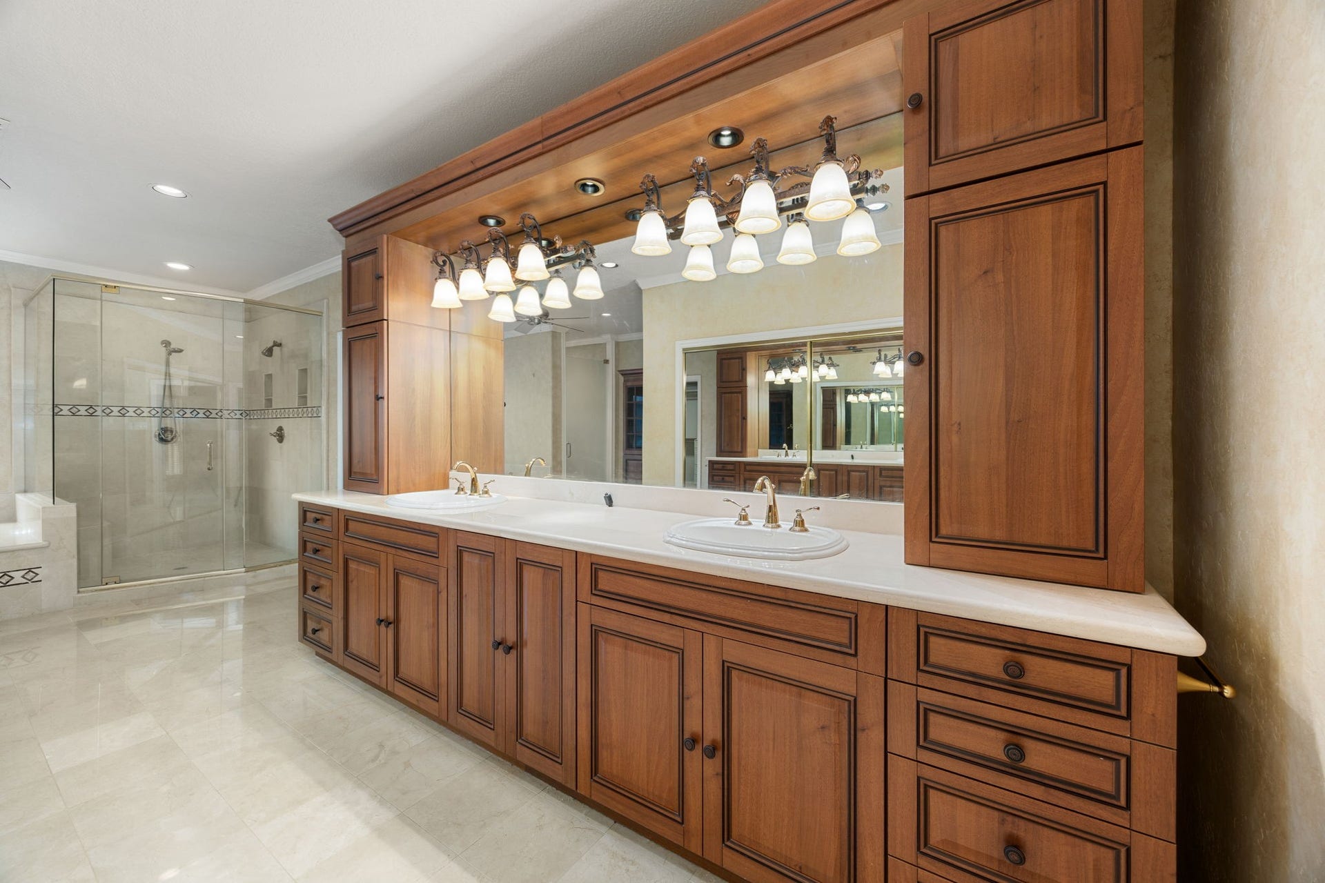 1602 Hannington Drive, Katy, TX 77450 The remodeled primary bath features an extended dual-sink vanity, updated lighting and a large glass-enclosed shower.