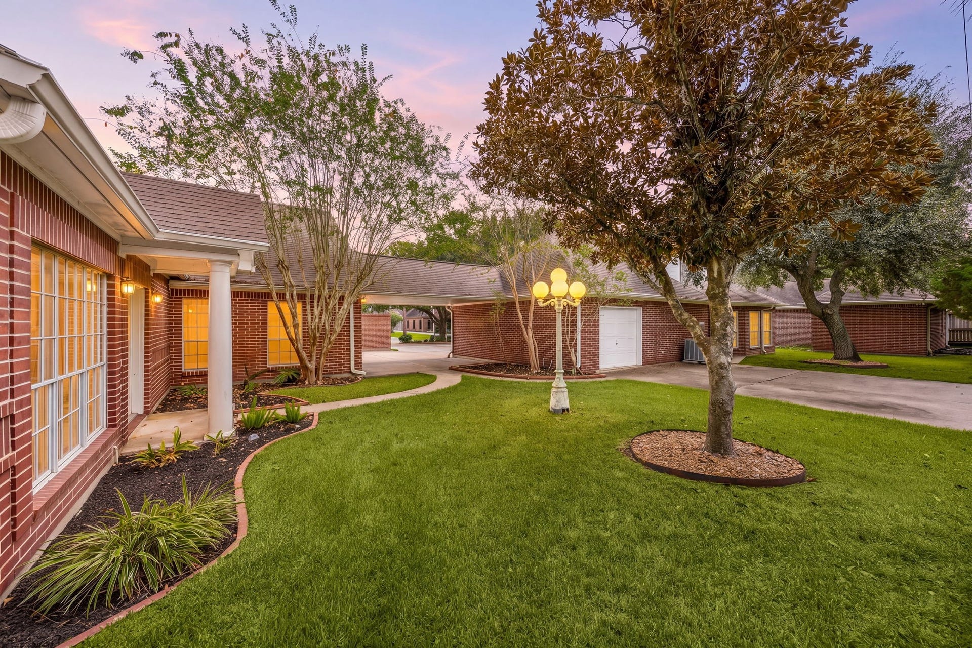 1602 Hannington Drive, Katy, TX 77450 At dusk, the covered breezeway and mature trees show another side of this unusually expansive property.