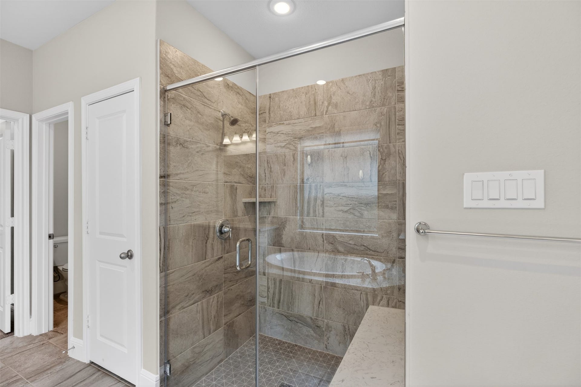 The oversized glass-enclosed walk-in shower with floor-to-ceiling tile creates a luxurious, spa-inspired atmosphere while adding timeless elegance. Its generous size offers plenty of room to start and end the day in comfort, transforming everyday routines into a relaxing experience.