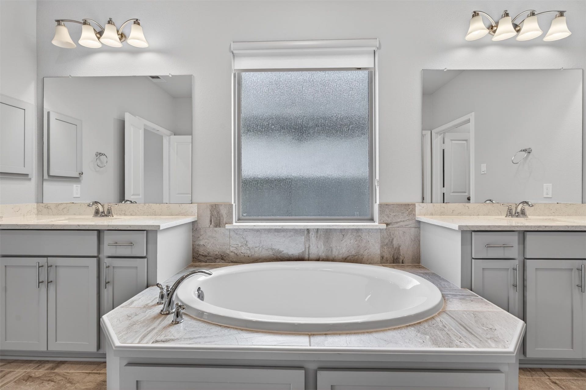 A large window above the tub fills the space with soft natural light, enhancing the spa-like ambiance. Imagine ending the day with a warm soak as sunlight filters through the window and the stresses of the day fade away.