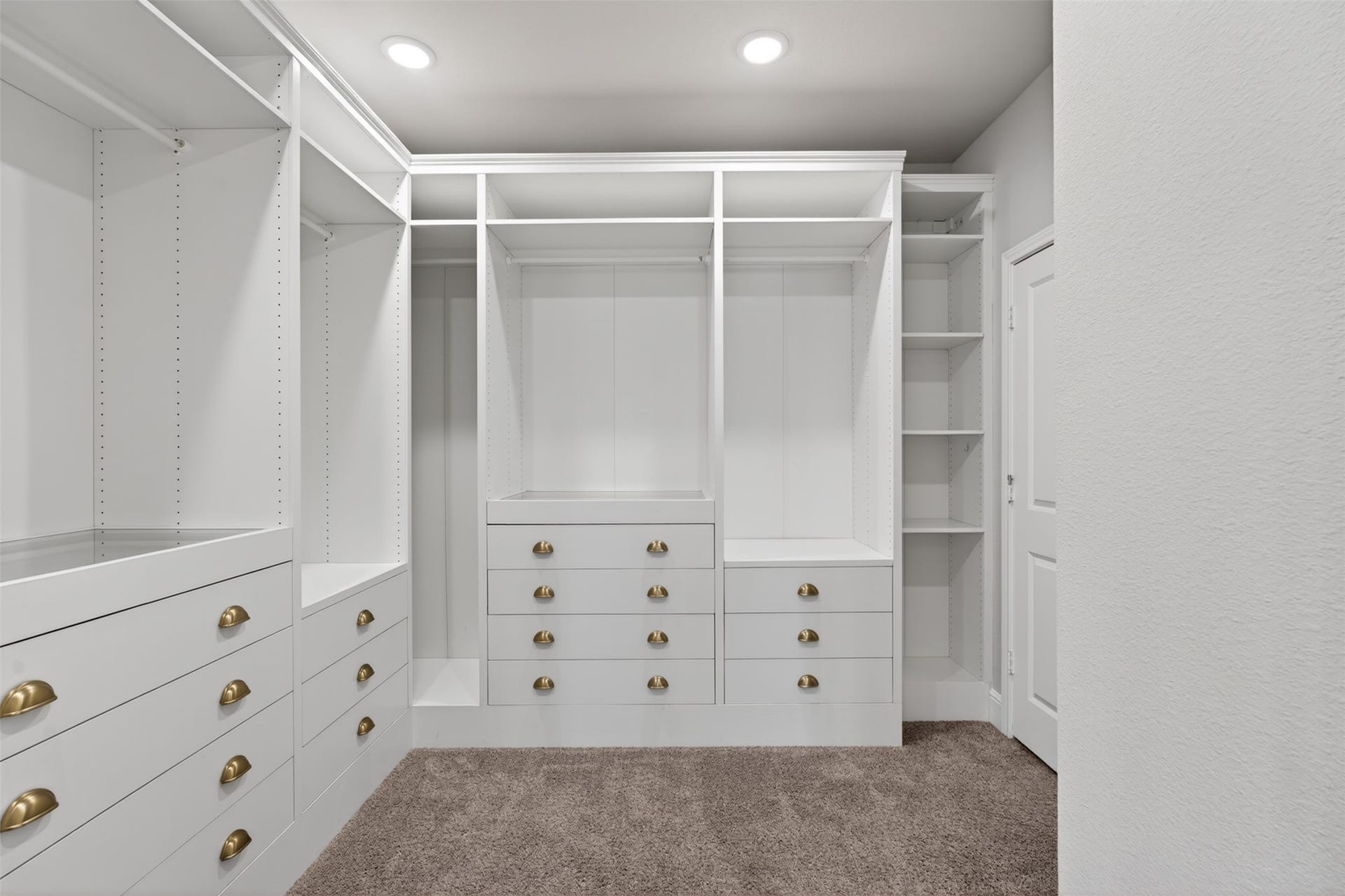 The expansive walk-in closet is beautifully appointed with built-in drawers, shelving, and dedicated storage solutions to keep everything organized and easily accessible. Thoughtfully designed for both functionality and convenience, the space offers room for every wardrobe essential. This custom closet provides the perfect finishing touch to the luxurious primary suite.