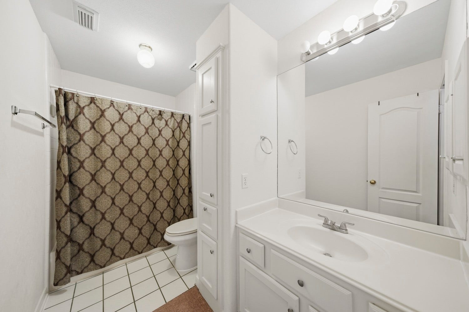 16 Fosters Court, Sugar Land, TX 77479 This bright full bathroom features a spacious vanity with generous counter space, a large wall mirror, and built-in cabinetry offering plenty of storage. A tub-and-shower combination provides everyday convenience, while the clean white finishes and tile flooring create a fresh, functional space ideal for family members or guests.