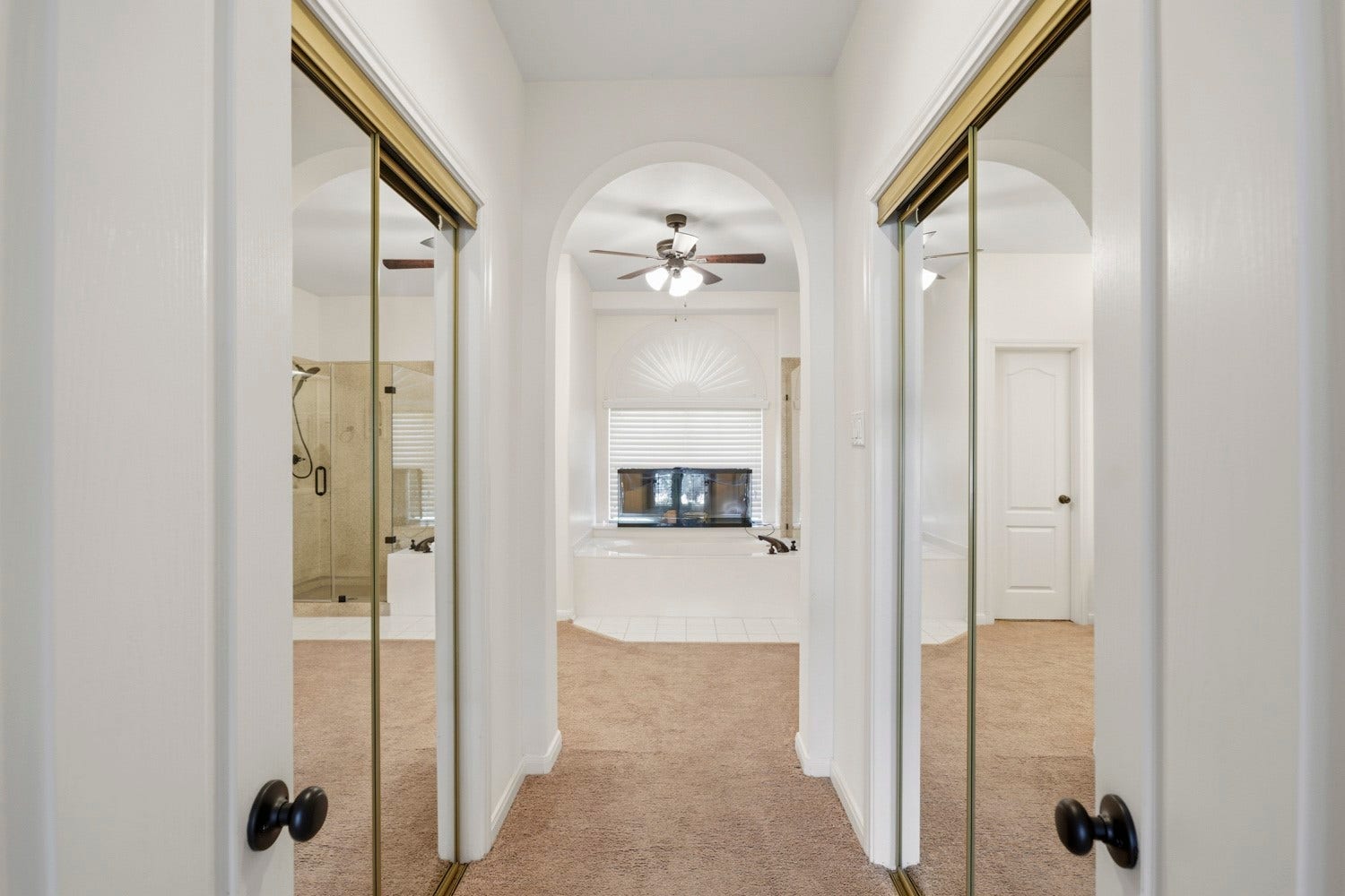 16 Fosters Court, Sugar Land, TX 77479 This thoughtfully designed primary suite features dual walk-in closets, offering generous storage and added convenience with separate closet spaces. Mirrored sliding doors enhance the sense of openness, while the arched entry creates a seamless transition into the spacious primary bathroom beyond.