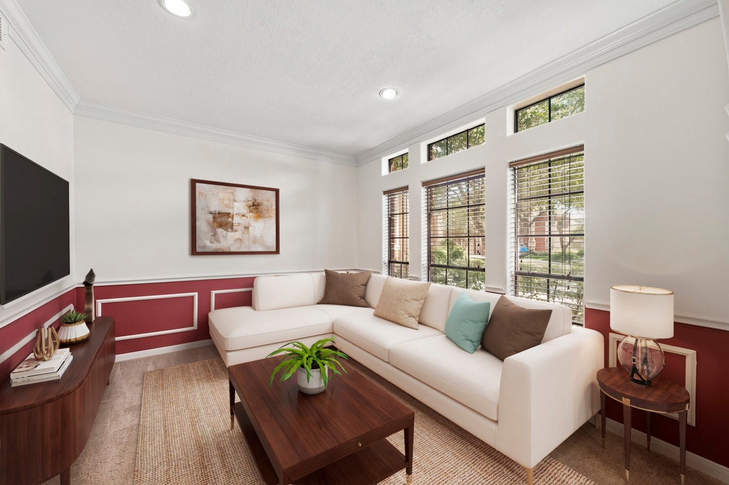 16 Fosters Court, Sugar Land, TX 77479 Virtually Staged: This inviting living room features abundant natural light from a wall of tall windows, complemented by additional transom windows above. Decorative wainscoting and crown molding add architectural character.
