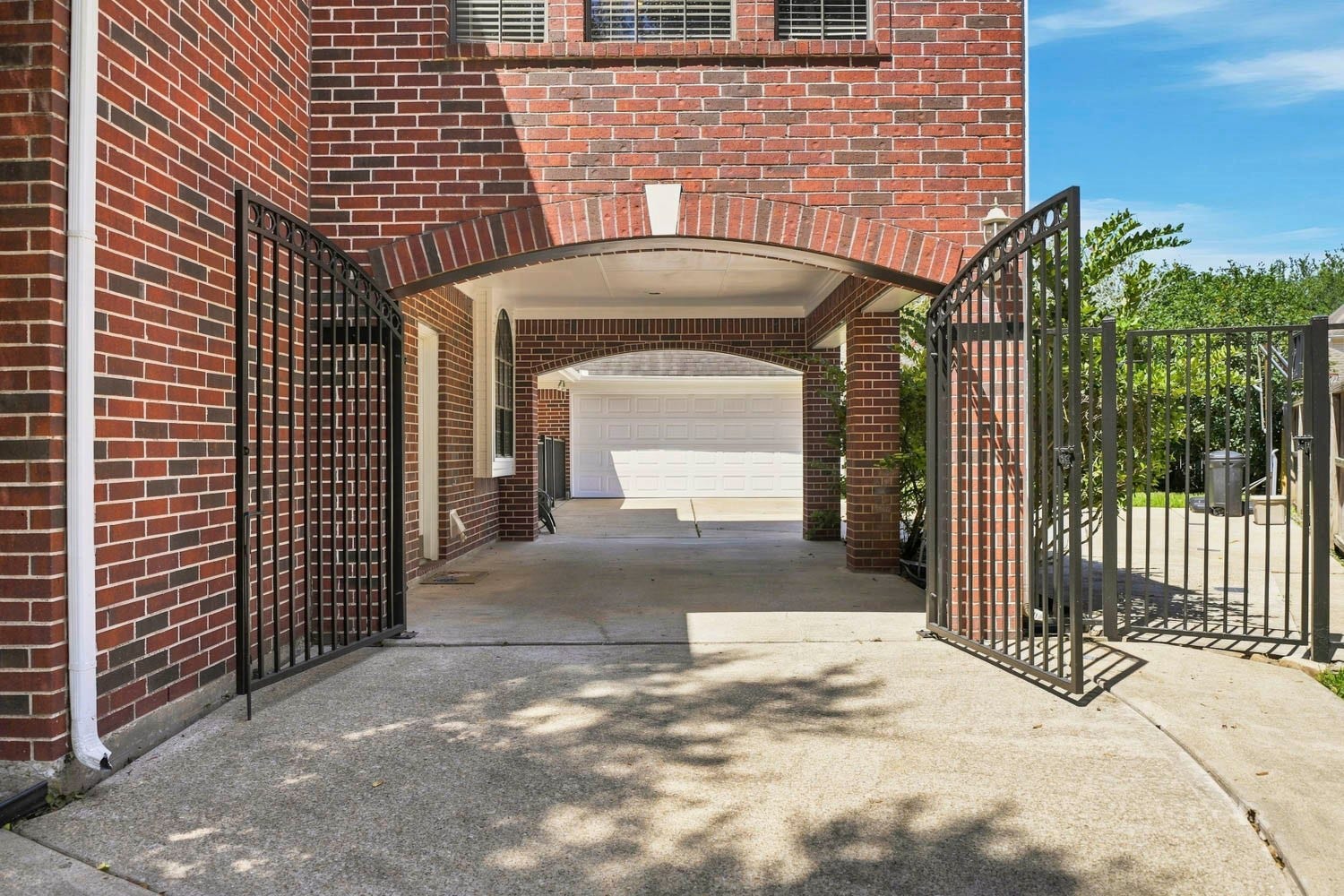 16 Fosters Court, Sugar Land, TX 77479 The brick archways and decorative wrought-iron gates complement the homes architecture while creating a protected passage and additional driveway space.