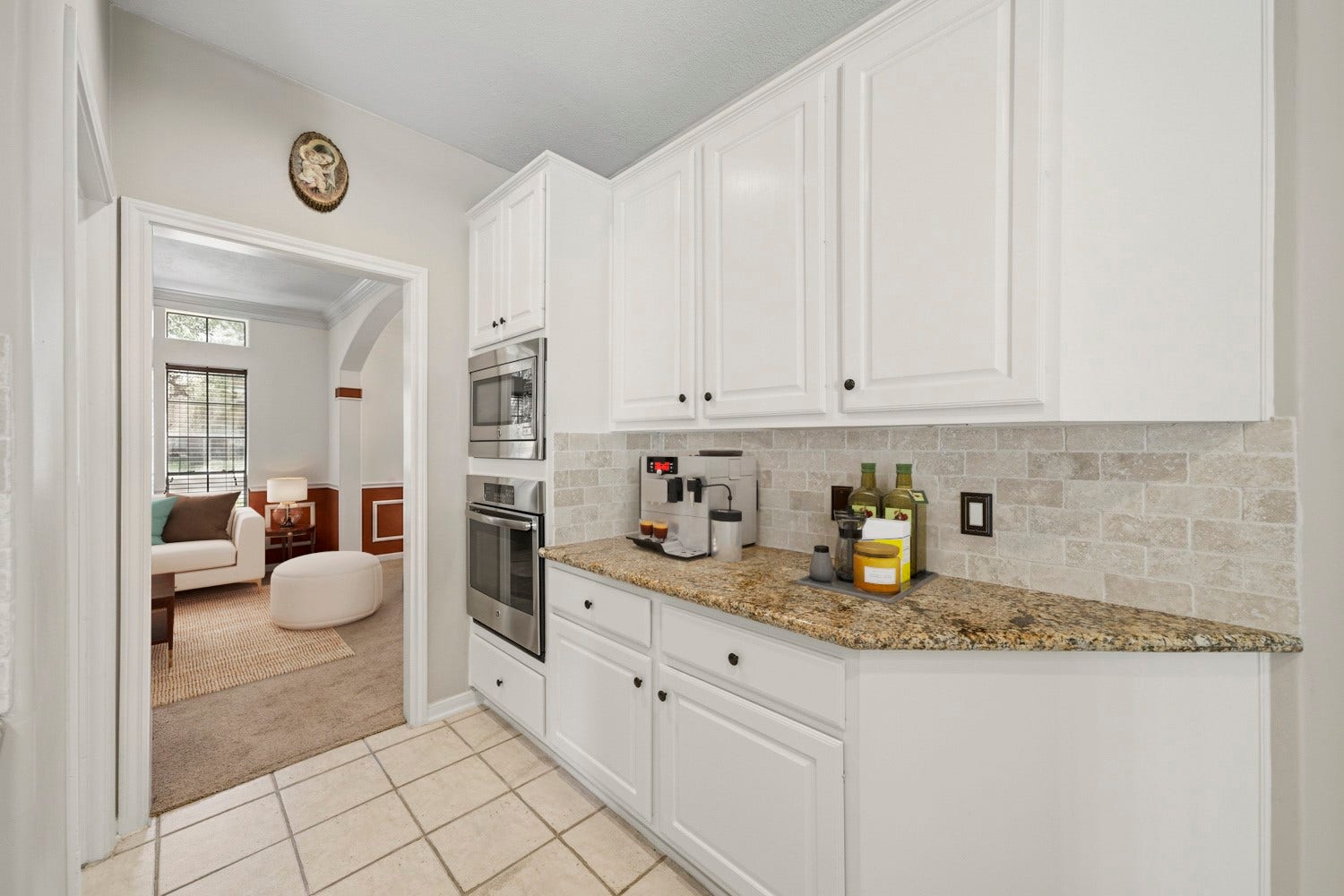 16 Fosters Court, Sugar Land, TX 77479 Virtually Staged: This well-appointed kitchen area offers abundant white cabinetry, granite countertops, and a neutral tile backsplash for a bright, classic look. Built-in stainless steel appliances maximize counter space, while the generous cabinetry provides plenty of storage.