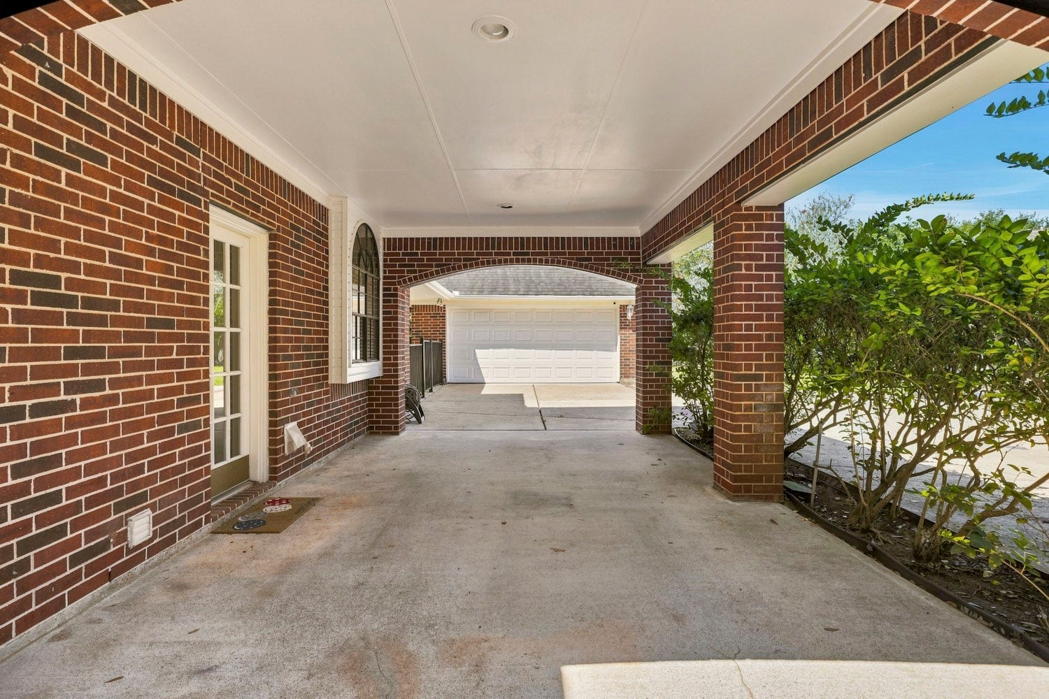 16 Fosters Court, Sugar Land, TX 77479 This gated porte-cochre provides convenient covered access between the home and detached garage, combining functionality with added privacy and security.