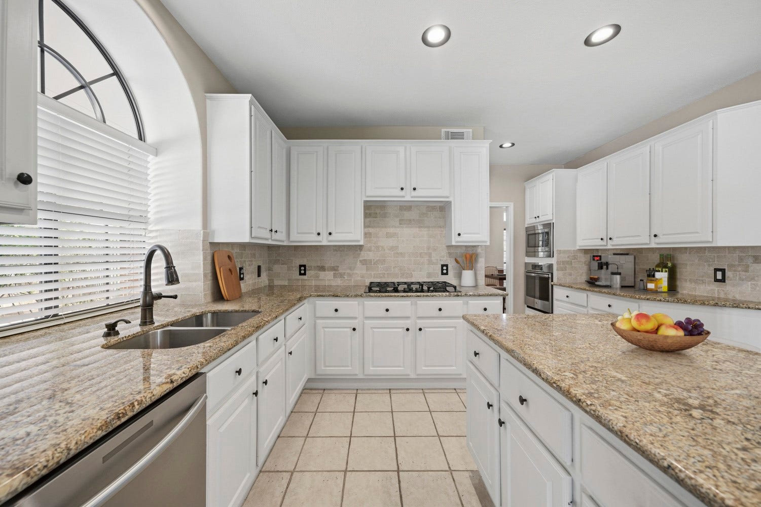 16 Fosters Court, Sugar Land, TX 77479 Virtually Staged: An arched window above the sink adds architectural character and natural light, while recessed lighting keeps the space bright and inviting.
