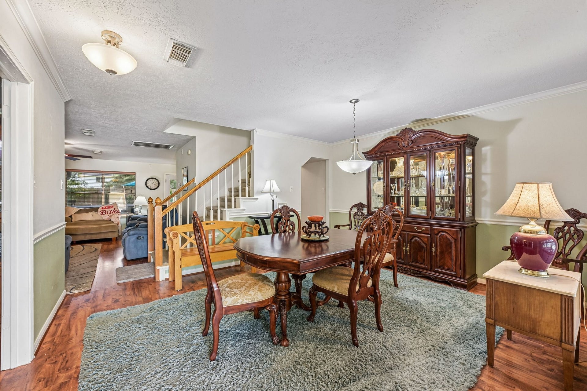 14219 Cypress Ridge Drive, Cypress, TX 77429 Elegant formal dining room featuring traditional chair rail molding, direct open view to the main living area, and adjacent staircase.