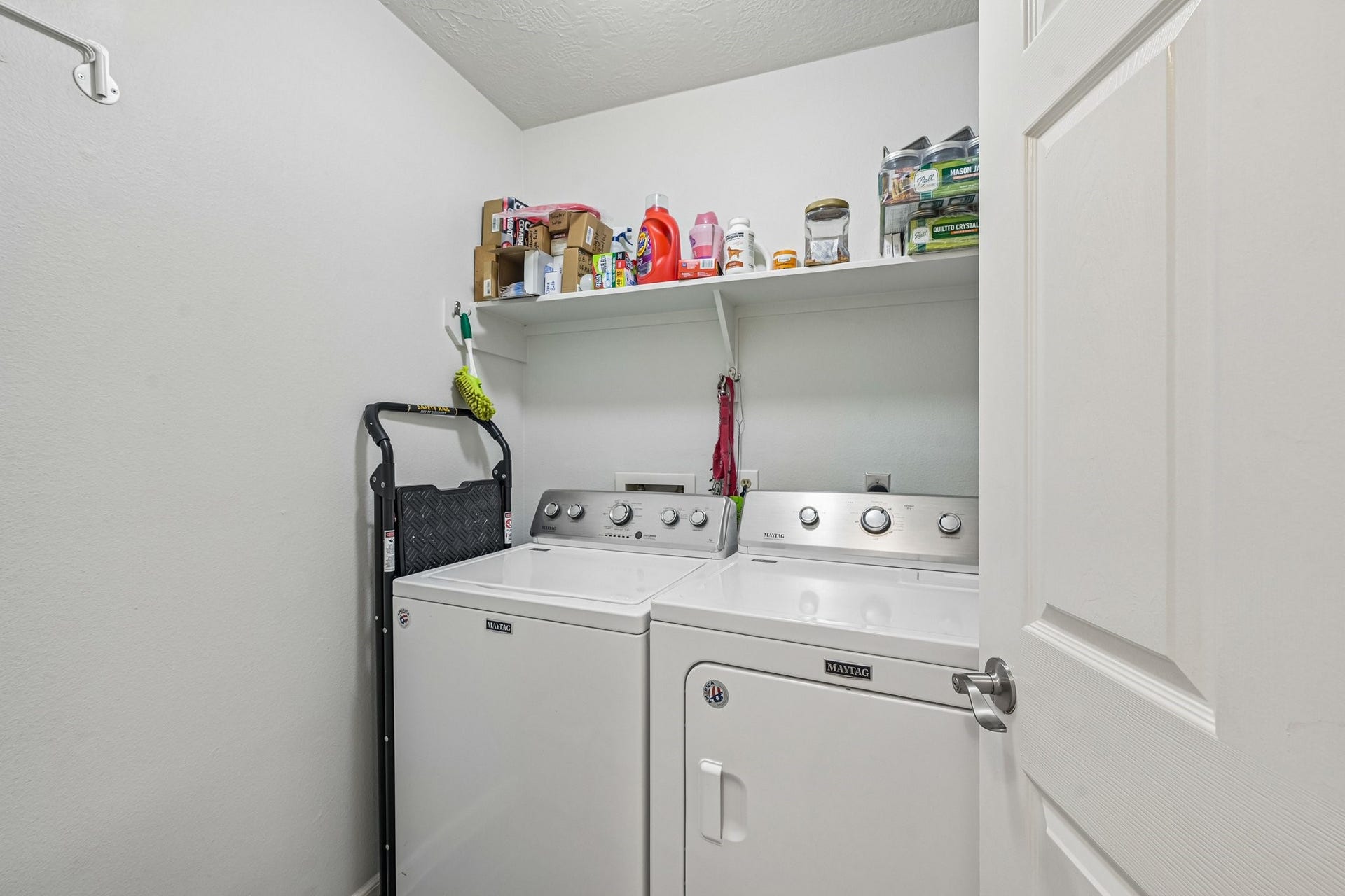 14219 Cypress Ridge Drive, Cypress, TX 77429 Dedicated indoor laundry room equipped with washer/dryer connections and overhead storage shelving.