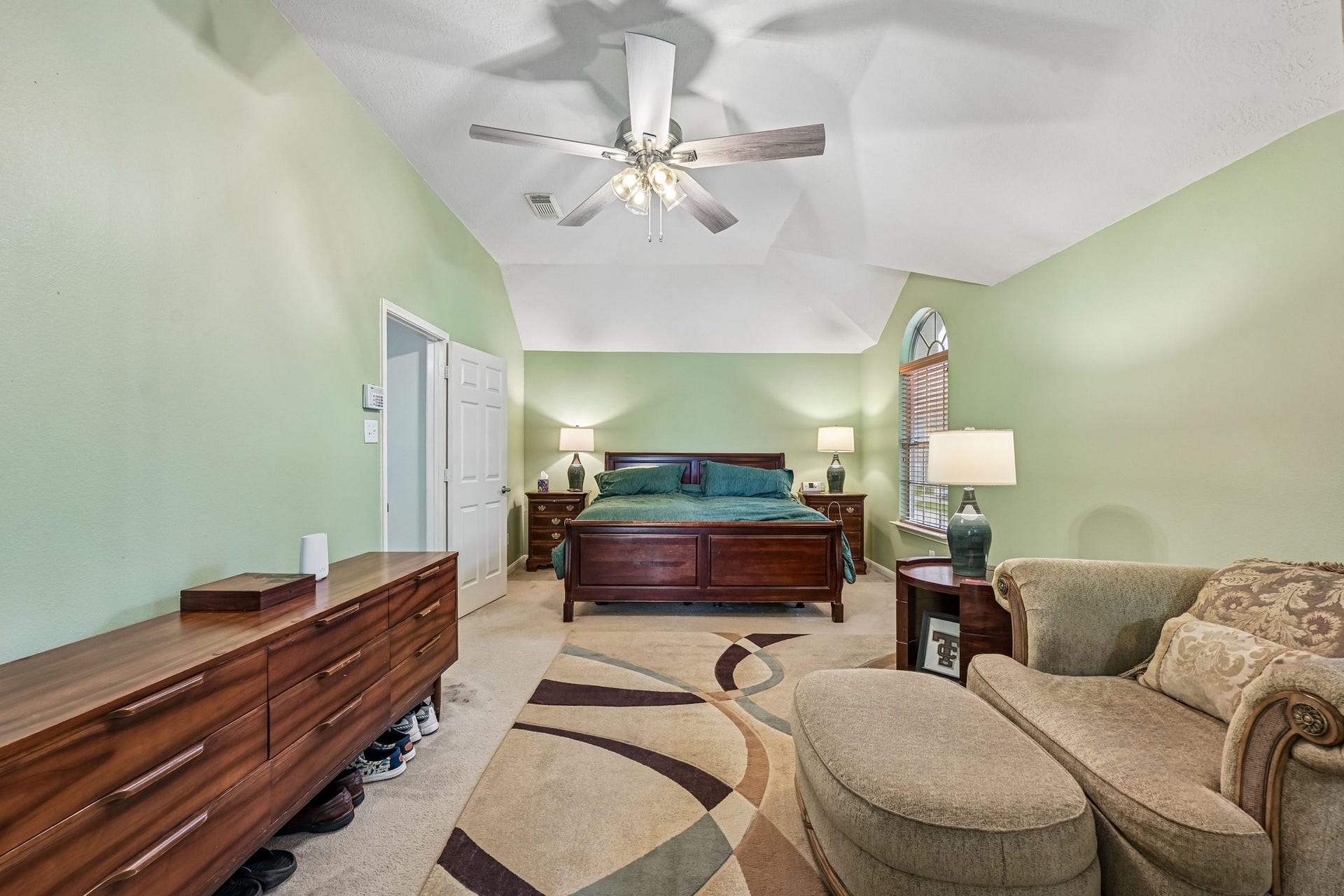 14219 Cypress Ridge Drive, Cypress, TX 77429 Primary bedroom suite showcasing vaulted ceilings, ceiling fan, generous floor space for large furniture, and en-suite access.
