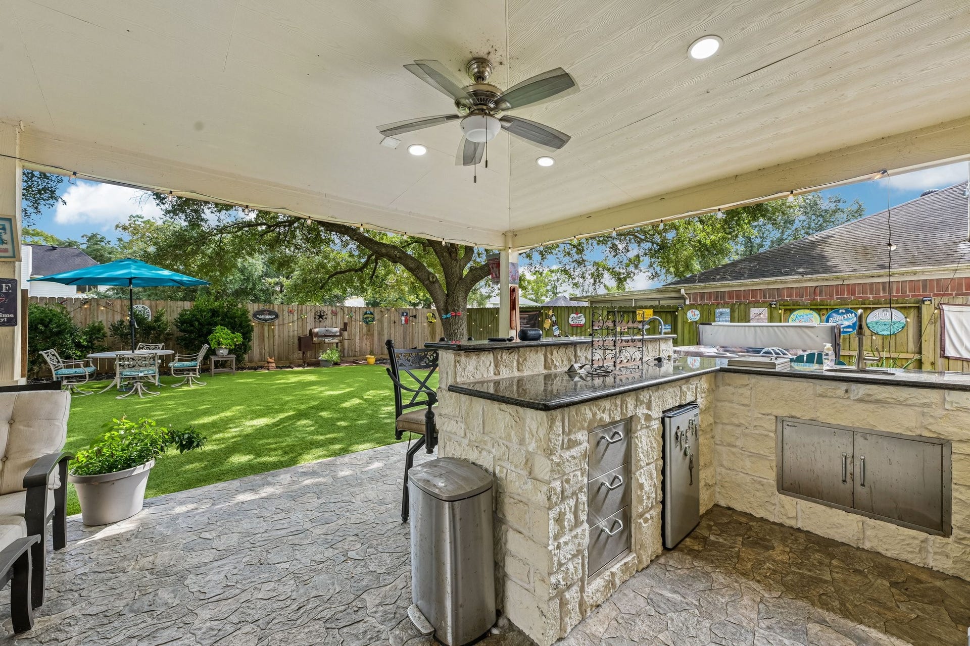 14219 Cypress Ridge Drive, Cypress, TX 77429 Fully equipped outdoor kitchen built with stone masonry, granite countertops, built-in stainless steel appliances, storage drawers, and a raised bar counter