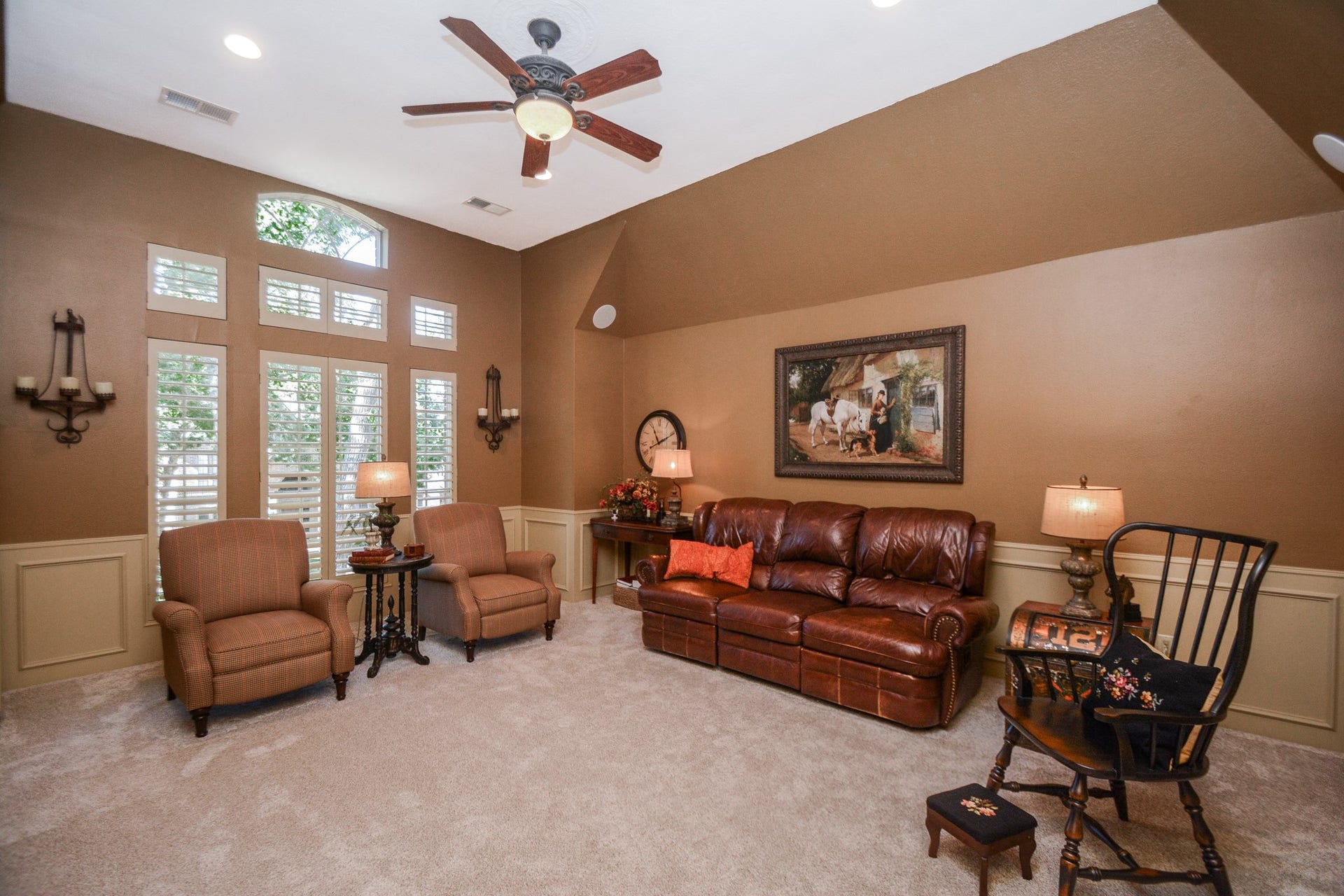 The upstairs game room, set here as a living area, offers a vaulted ceiling, tall windows, and fresh carpeting installed in October 2026.