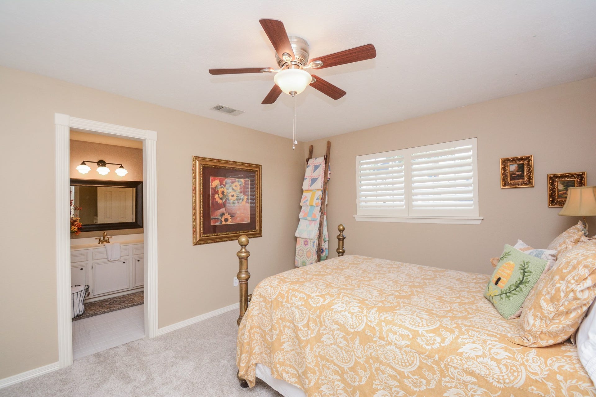This comfortable upstairs secondary bedroom features plantation shutters and access to an adjoining en-suite bathroom.