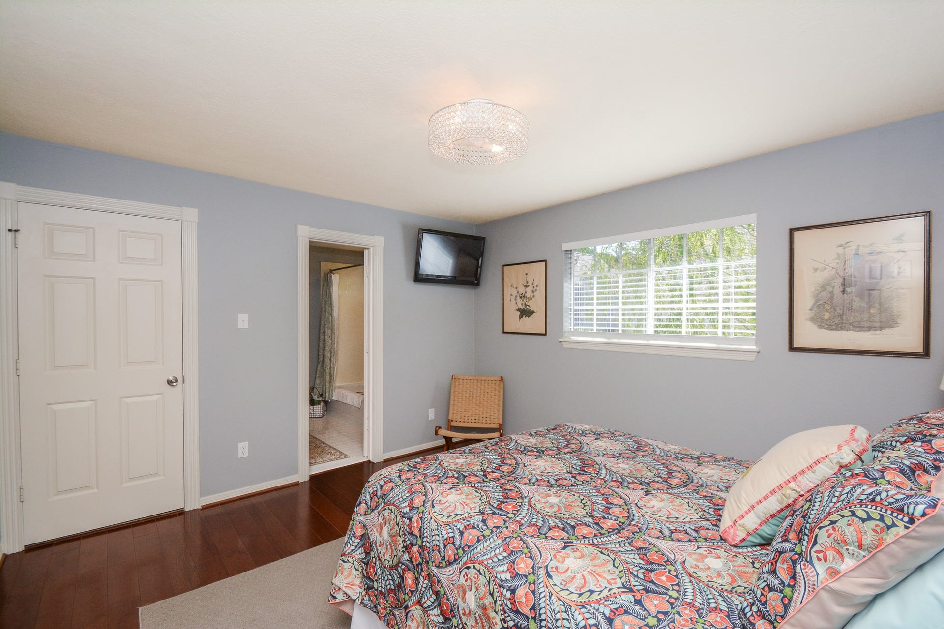 This alternate bedroom view highlights the wood flooring, closet, and access to the adjoining ensuite bathroom.