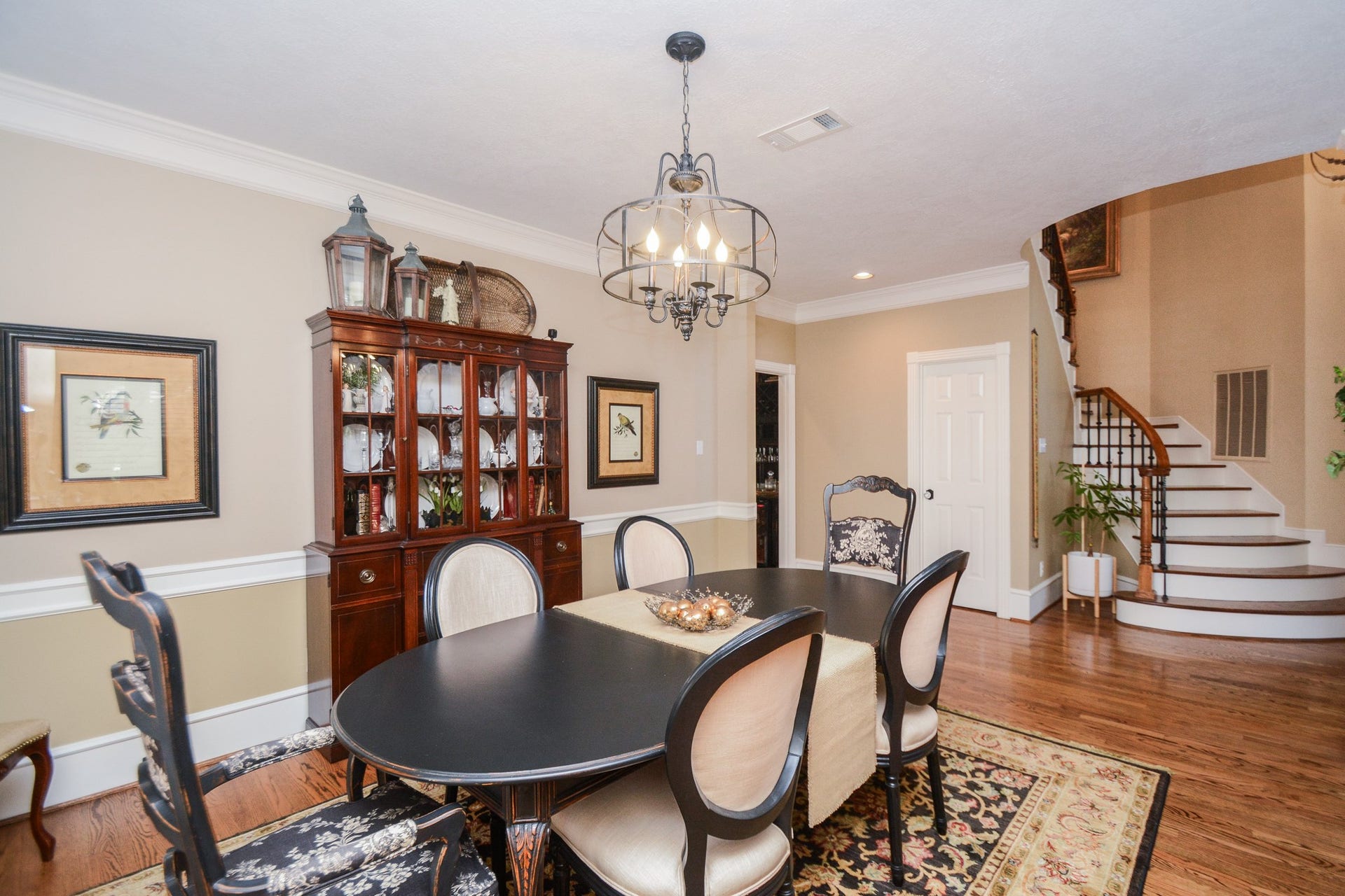 The formal dining room features hardwood flooring, a decorative chandelier, and convenient access to the adjoining living area.