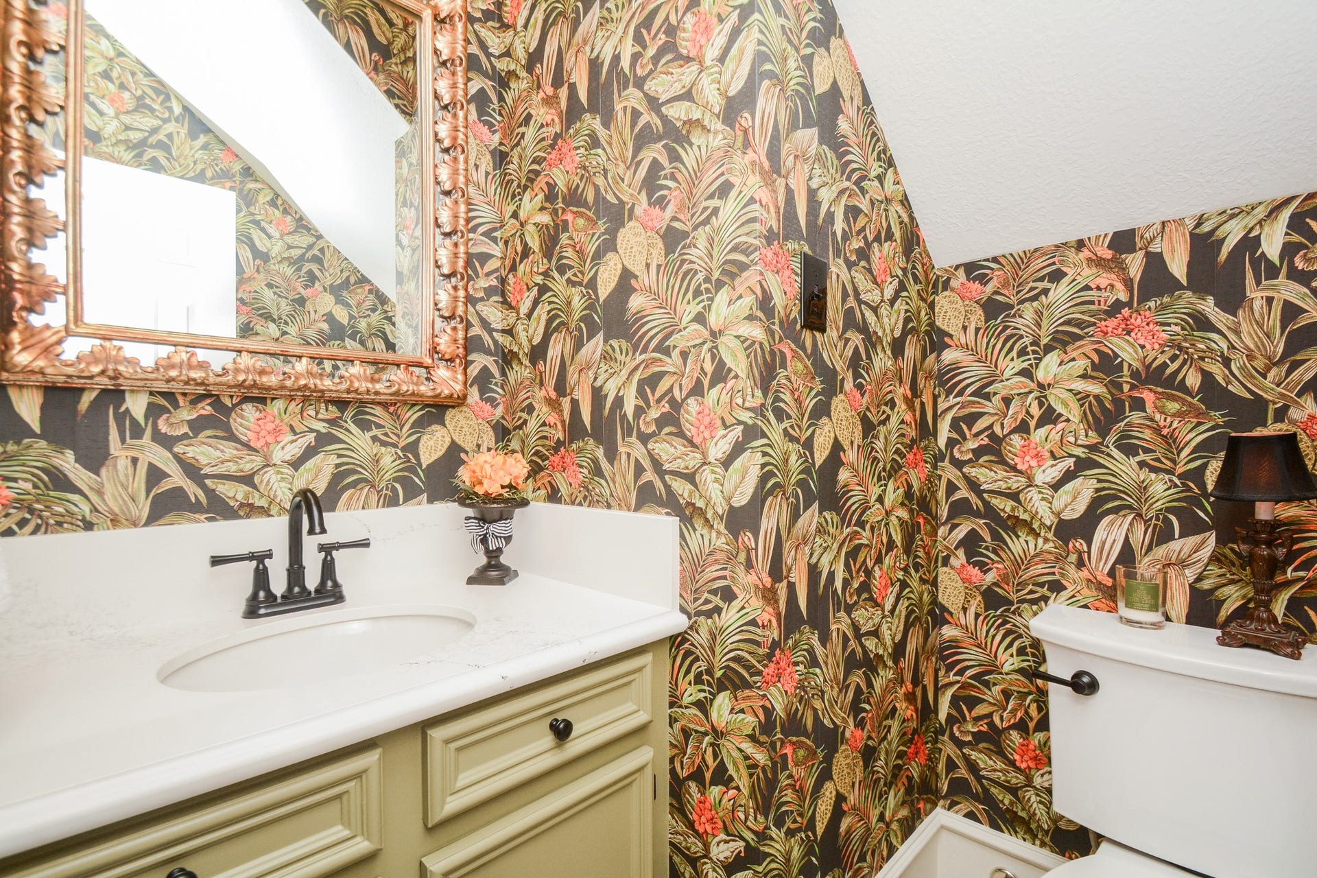 Botanical wallpaper and a decorative mirror bring distinctive character to this convenient first-floor powder room.
