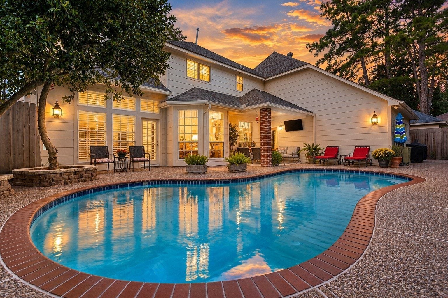 The backyard pool reflects the homes warm evening glow, creating an inviting setting for relaxing or entertaining.