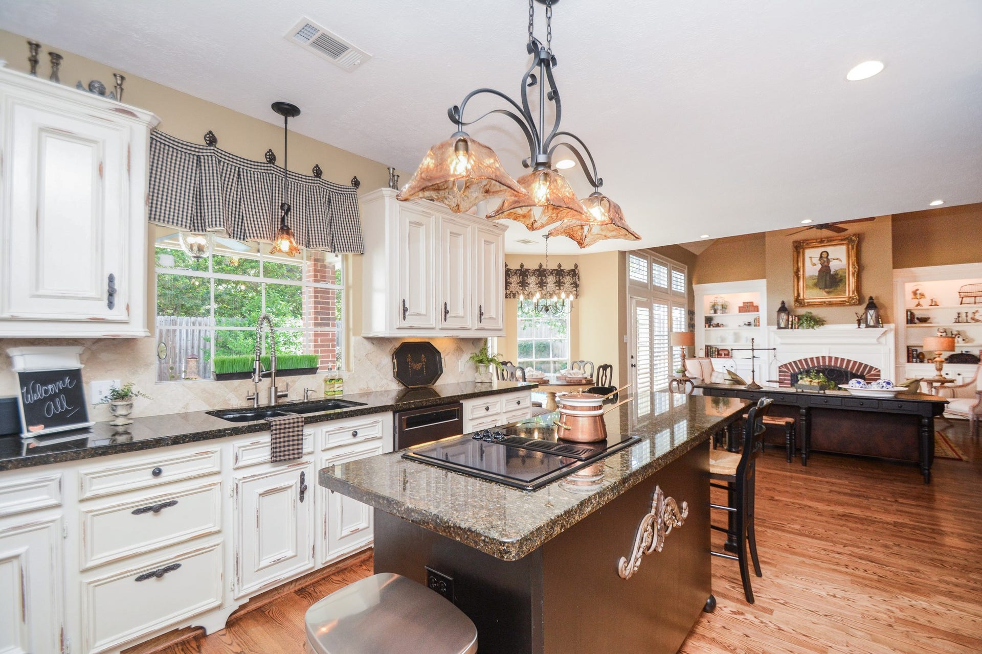 The kitchens island cooktop and seating area overlook the adjoining family room, keeping everyday living comfortably connected.