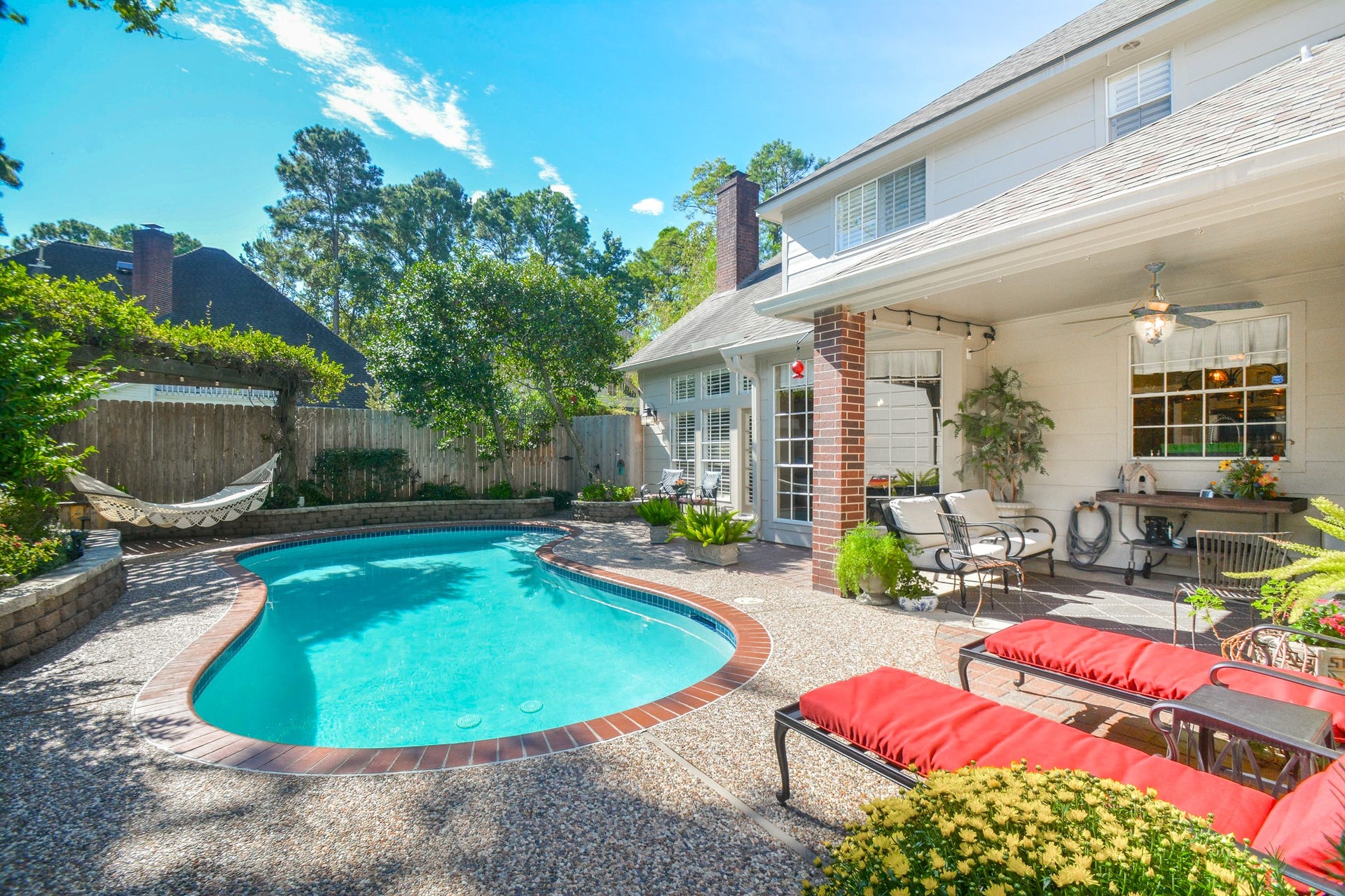 A sparkling pool, spacious deck, and covered patio create an inviting backyard retreat.