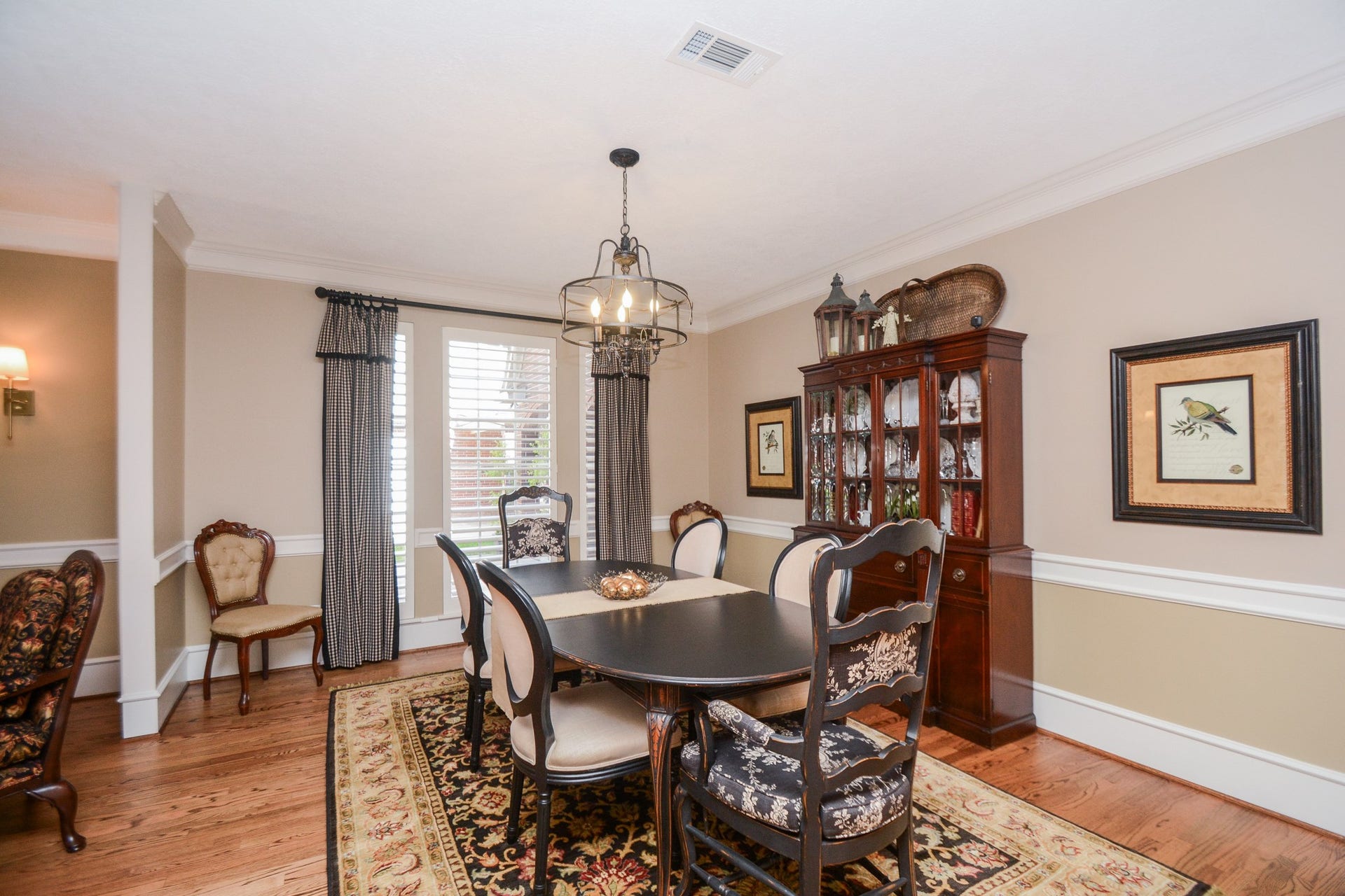 Beautiful hardwood flooring, crown molding, and a decorative chandelier create an inviting setting in the formal dining room.